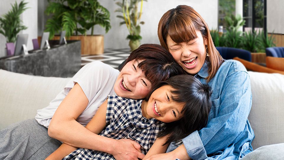 Mom and two kids lauhging on couch 