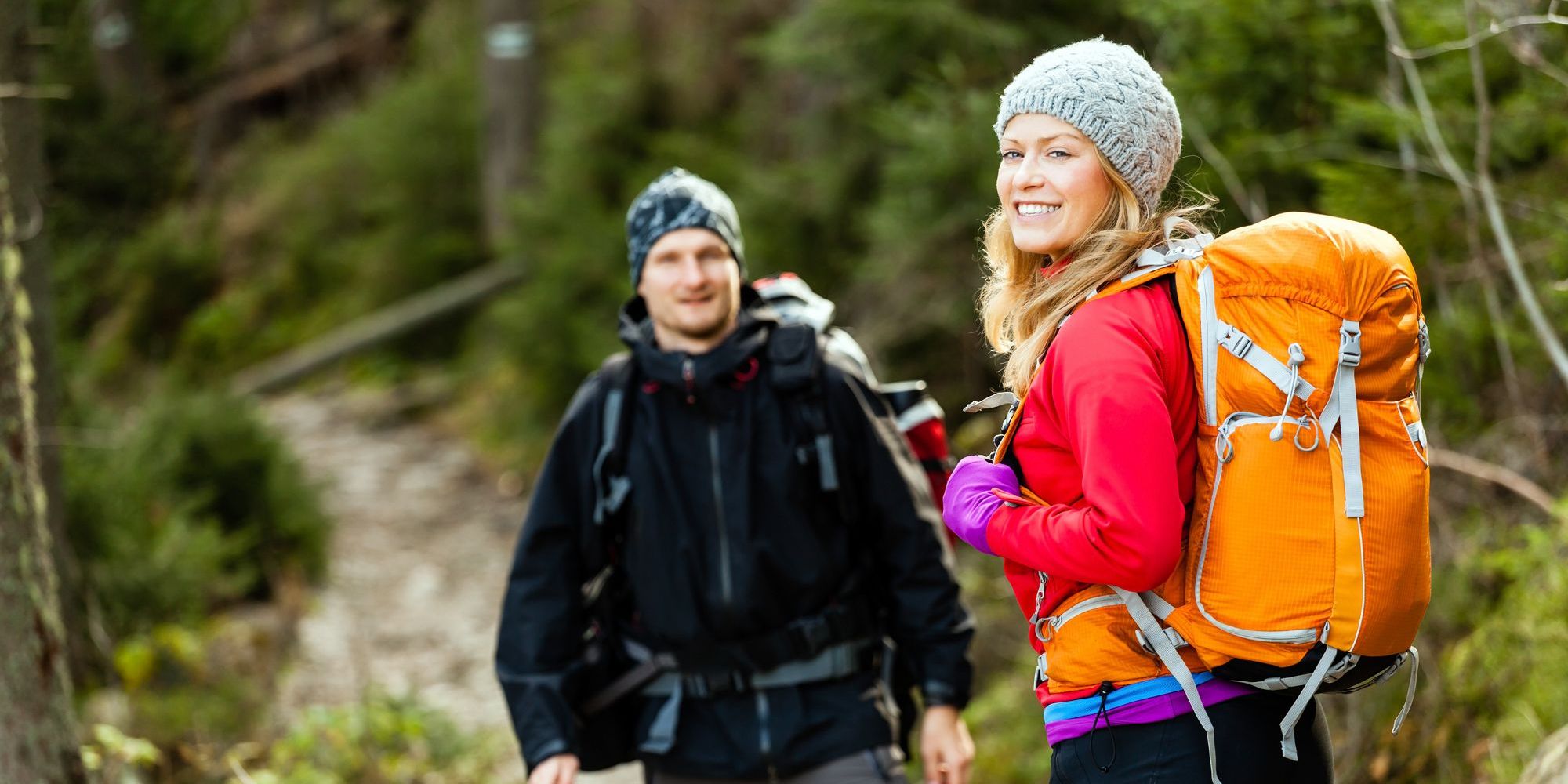 A woman and man on a hike smiling at the camera.