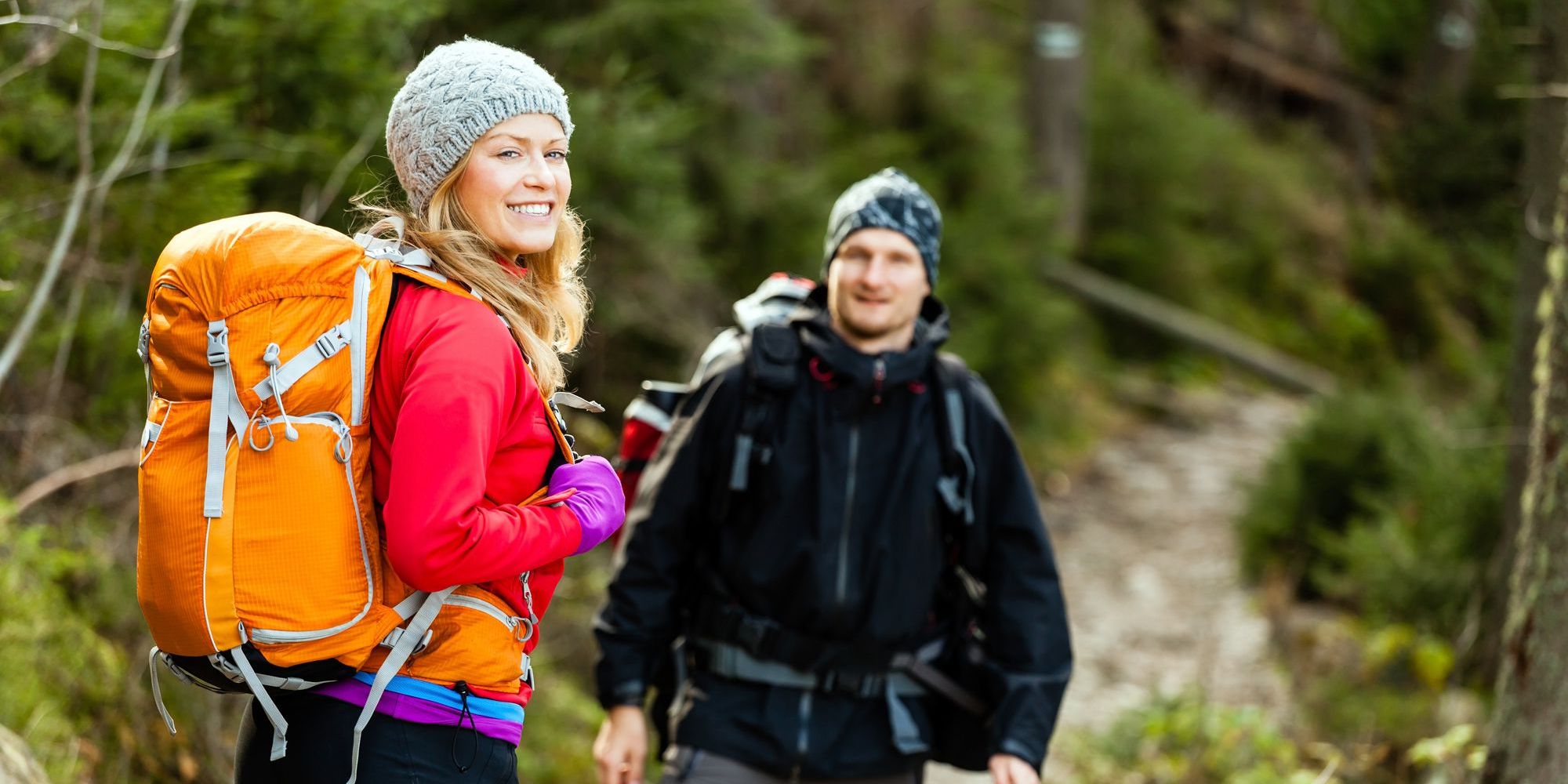 A woman and man on a hike smiling at the camera.
