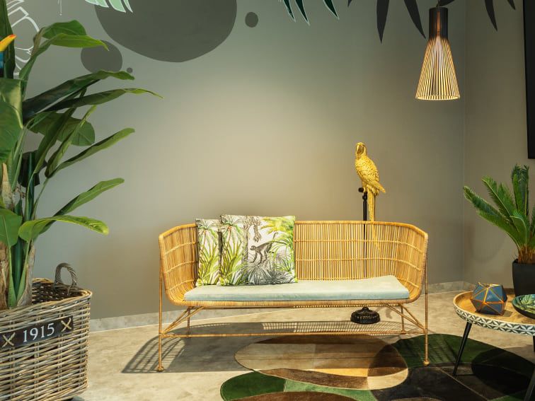 Cosy wicker couch in lobby with decorative pillows