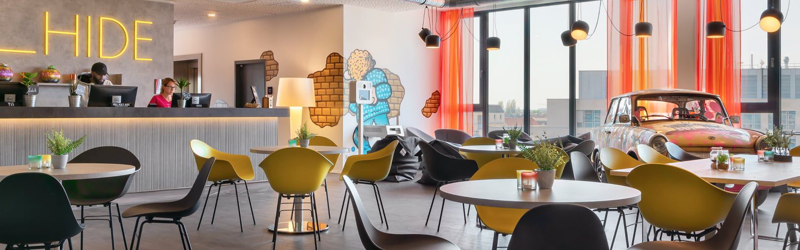 Restaurant mit Stühlen, Tischen und einem dekorativen Auto