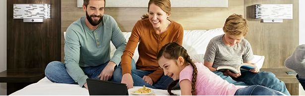 Eine Familie zusammen auf einem Hotelbett