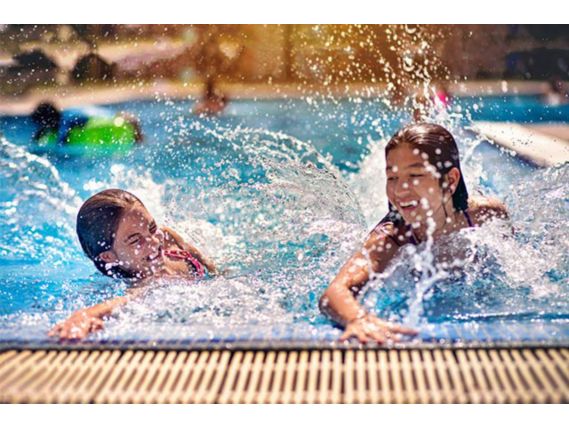 Two girls splashing in a pool