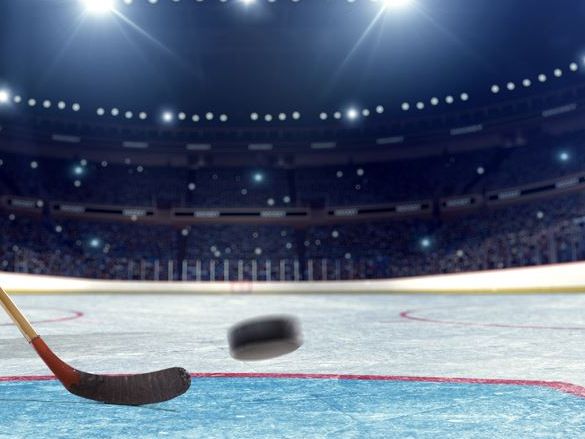 Hockey stick and puck on ice rink 