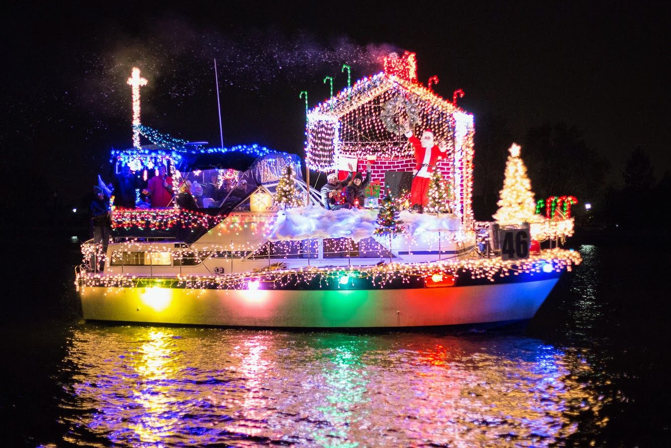 Boat on the water deced out wth holiday lights and decor.