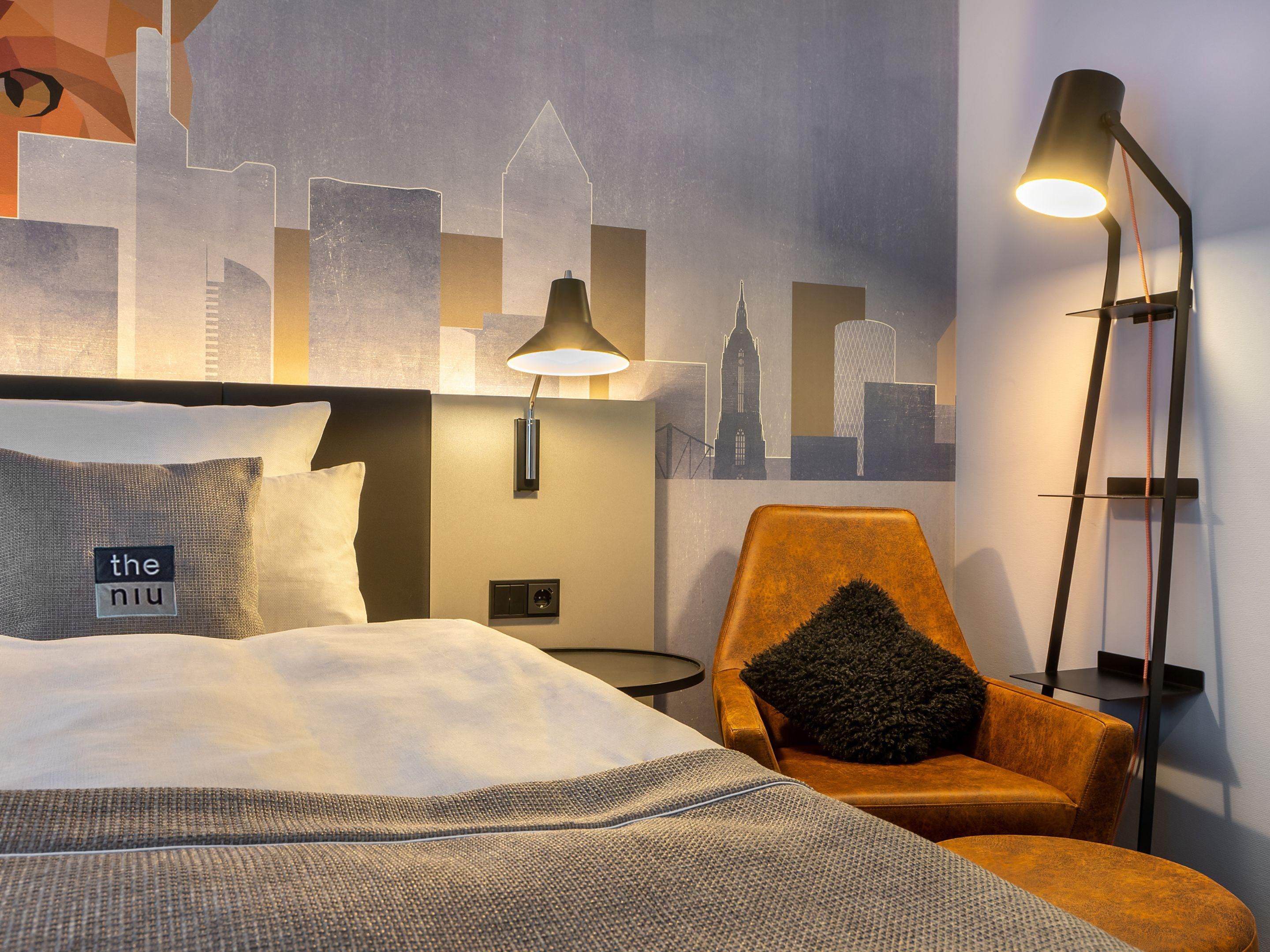 Im Holiday Inn - the niu, Charly Frankfurt City lässt Nils Kasiske, Kopf von Studio Topie, das Frankfurter Bahnhofsviertel mit viel Humor und Farbe aufleben. Seine Werke entstehen aus einer „Verkettung von Umständen” und verwandeln sich in lebendige, pointierte Murals. Eine spielerische Kunstreise voller Witz und Energie erwartet Sie. Augen auf!