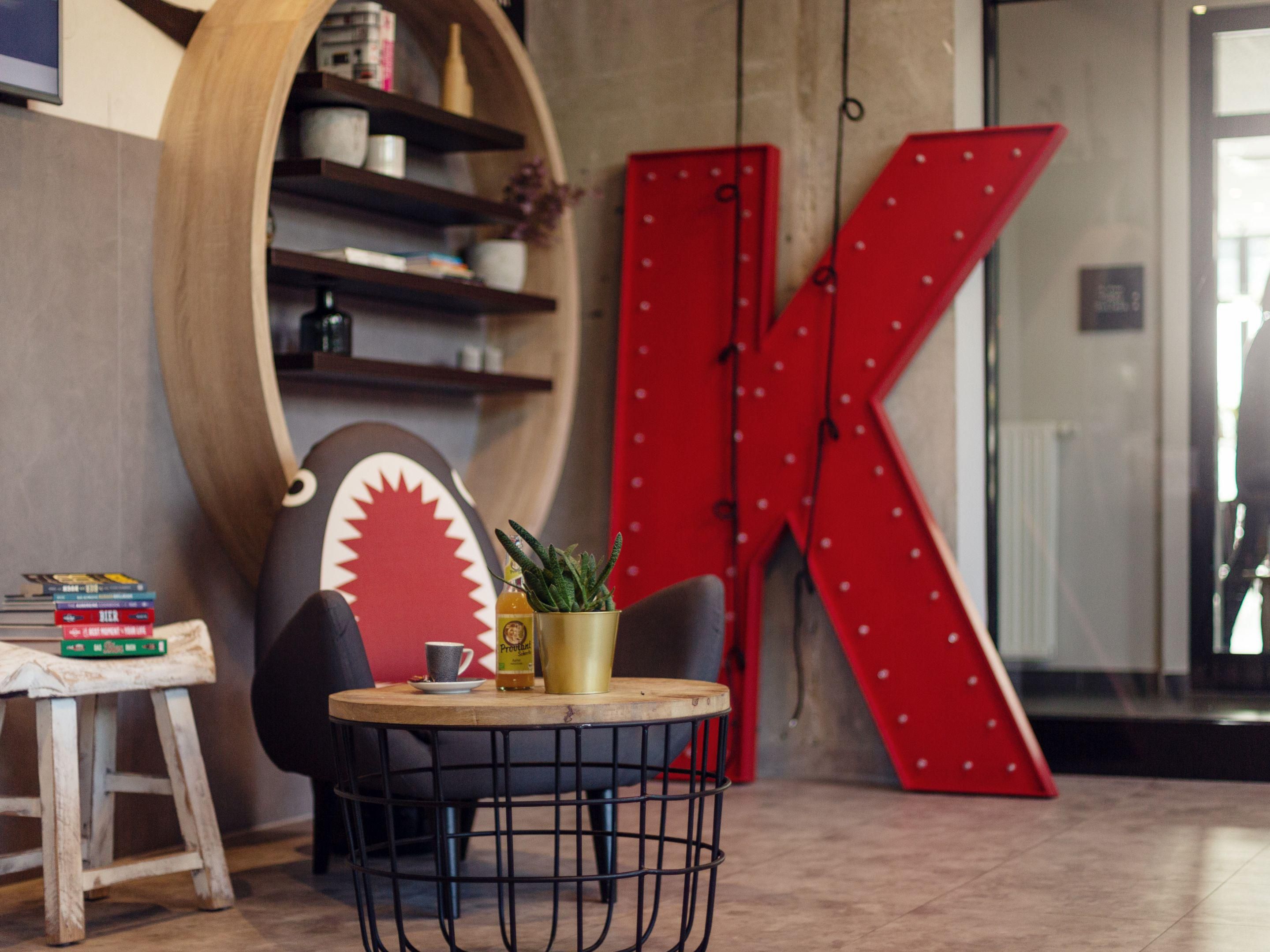 The hotel's interior combines North German harbor flair with a modern style. Industrial and maritime elements, such as rope lamps and cabin tables, create an inviting atmosphere. The blend of Nordic elegance and rugged industrial design is enriched by the vibrant graffiti of Rebelzer.