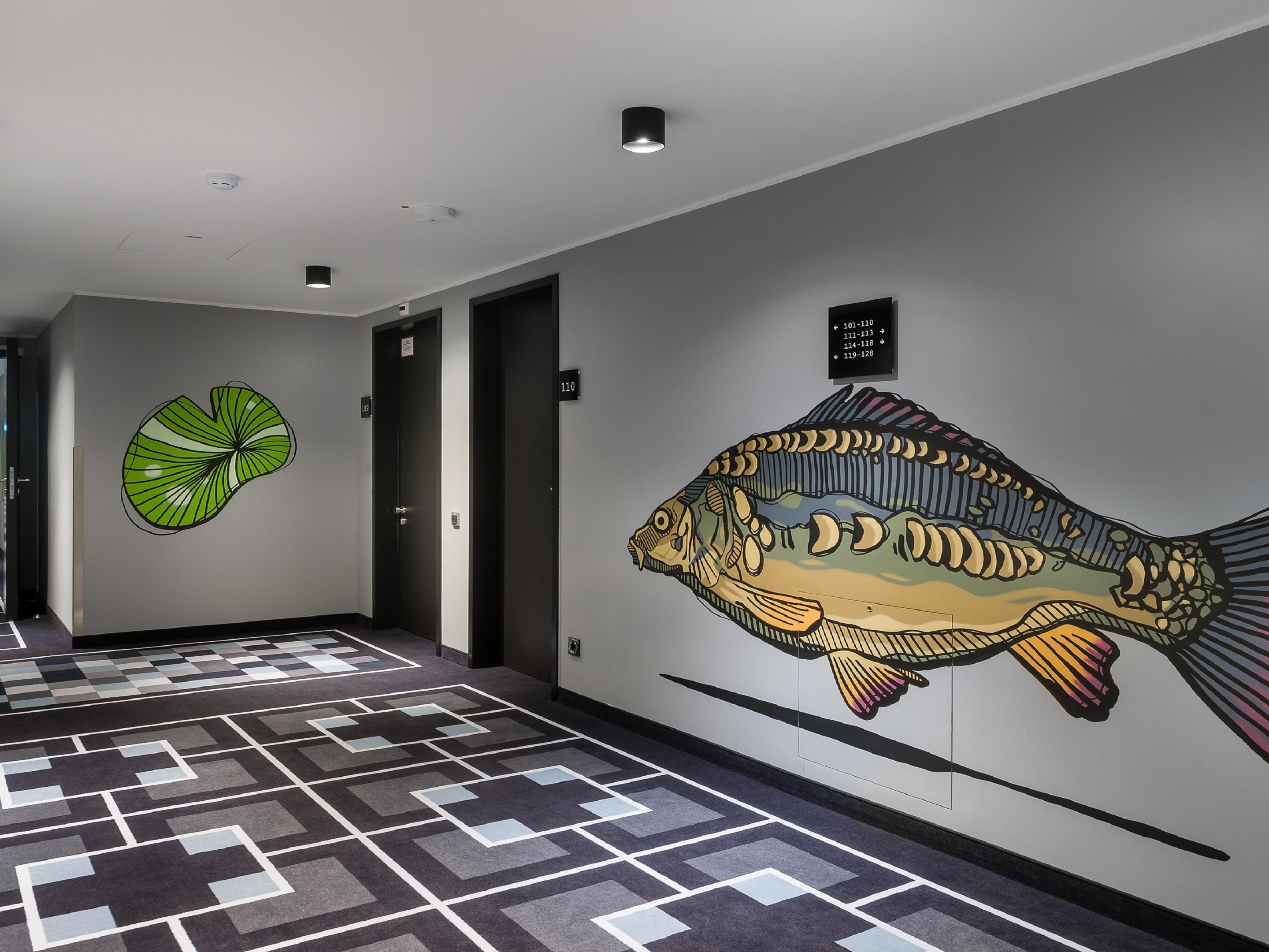 Jens Richter brings Mannheim’s colourful energy indoors. Using spray cans, brushes, and bold ideas, he fills hallways with giant parrots, forest creatures, and oversized leaves. His street art is playful, striking, and larger-than-life—turning every corner into a mini urban safari and your hotel stay in Mannheim into a visual adventure.