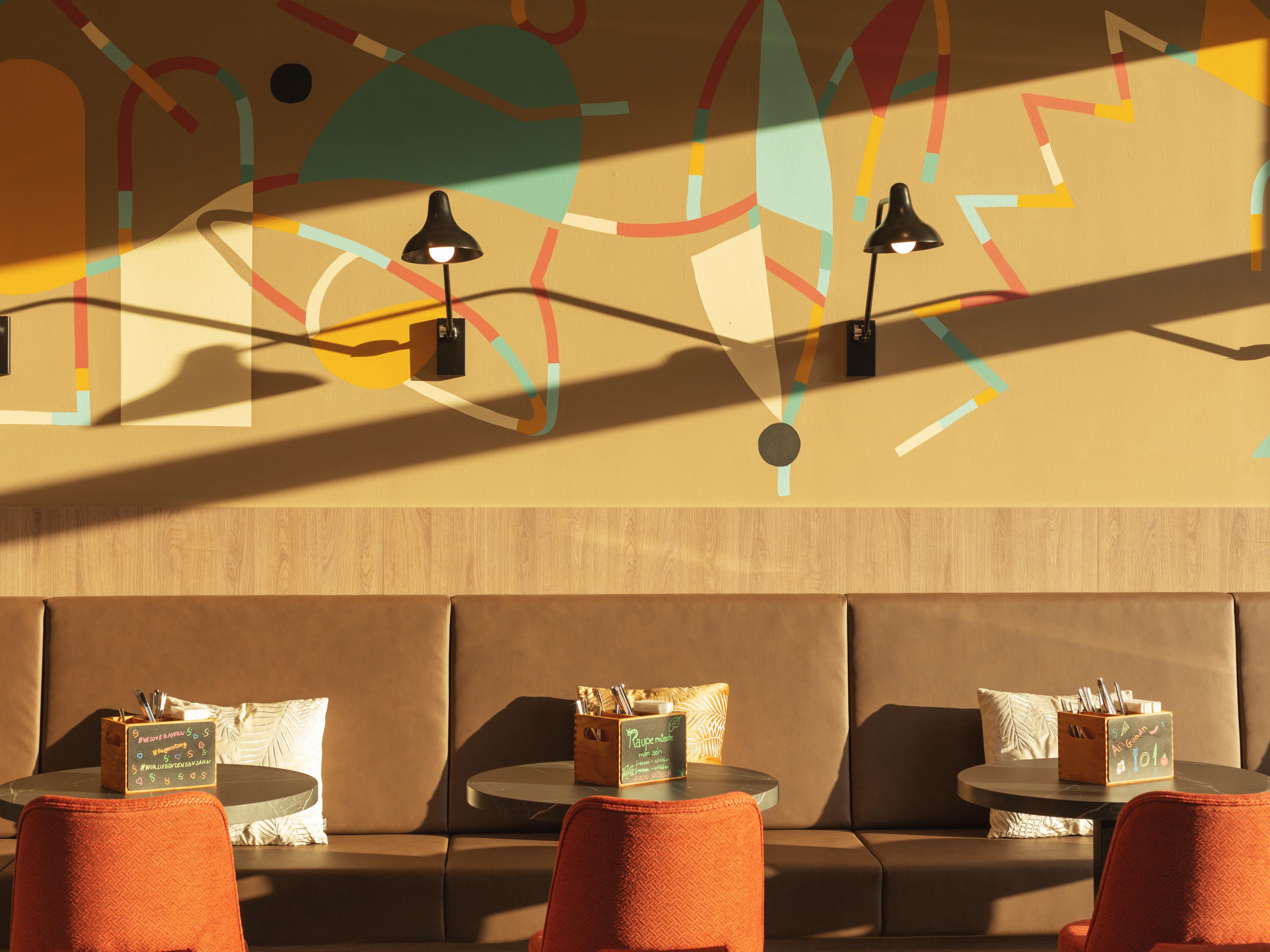 The street-art trio Guapo Sapo—ISAKOV, JU MU, and KRASHKID—has brought their colourful, acrobatic style to our hotel in Regensburg. From the cathedral to the Danube, their murals capture the city’s energy. Six floors of illustrative walls turn our design hotel into a moving, urban gallery, where every corner sparks a “wow.”