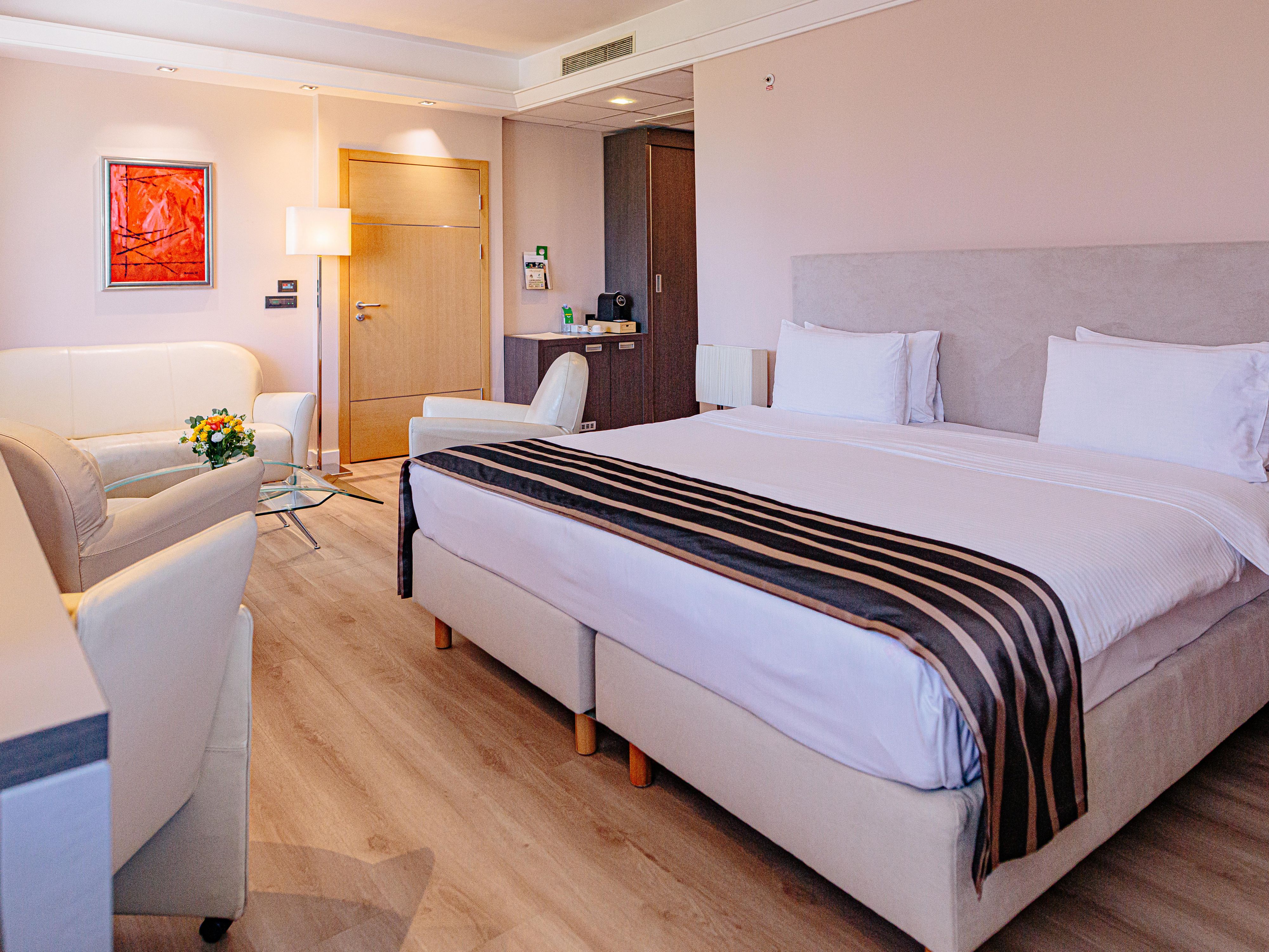 Spacious suite with king bed, living room area and stocked minibar