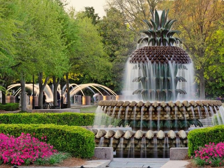 Water fountain in a park with blooming flowers