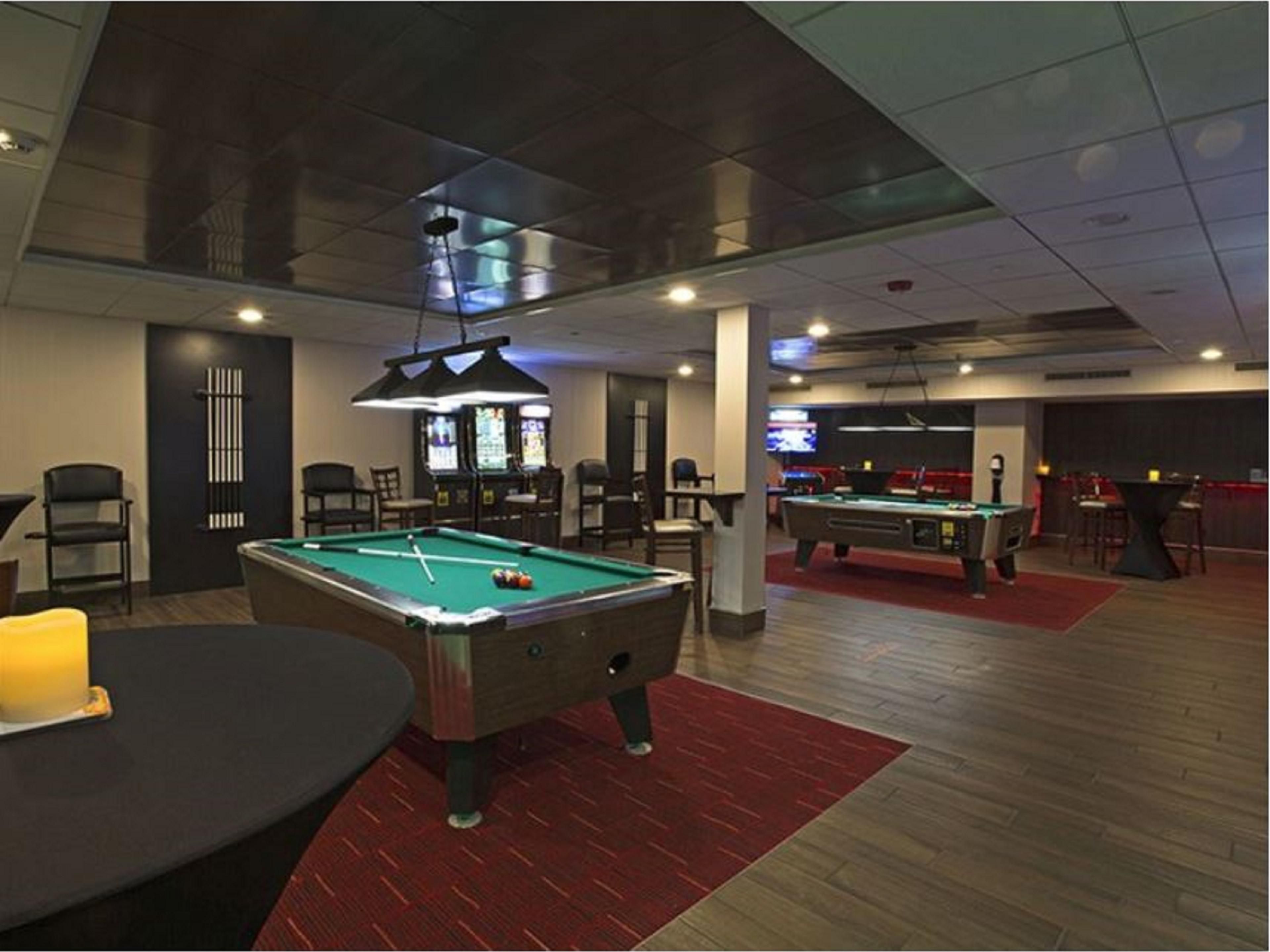 As with any traditional speakeasy, ours is a hidden space that can be found only via our Lobby Bar. Buried behind a convincing bookshelf, our bartender will open the passageway to this eclectic entertainment space. The Speakeasy is outfitted with TVs on the walls, a jukebox, pool tables, golden tee golf, darts, and silver strike bowling.