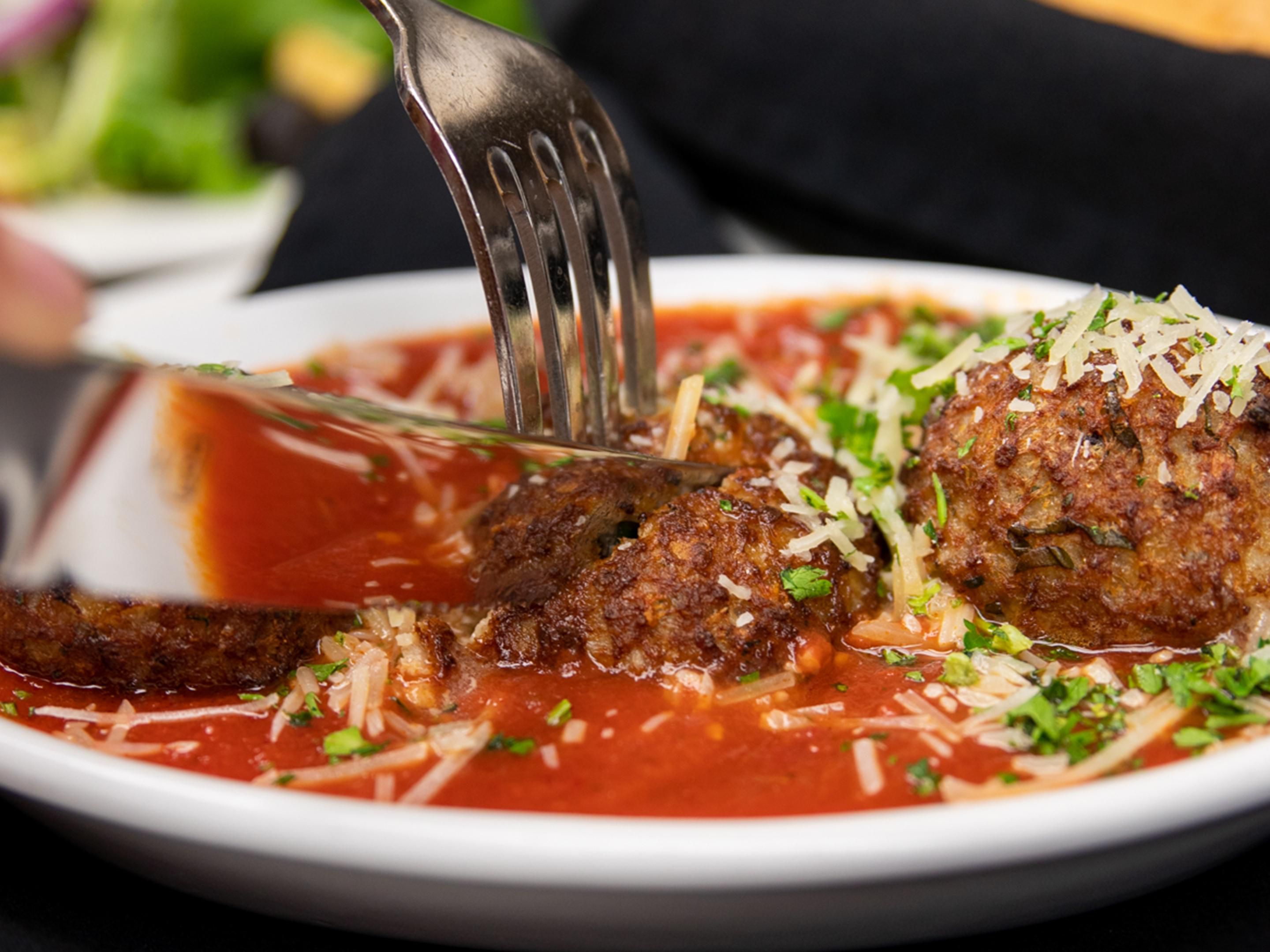 Cutting into a red sauce meat dish