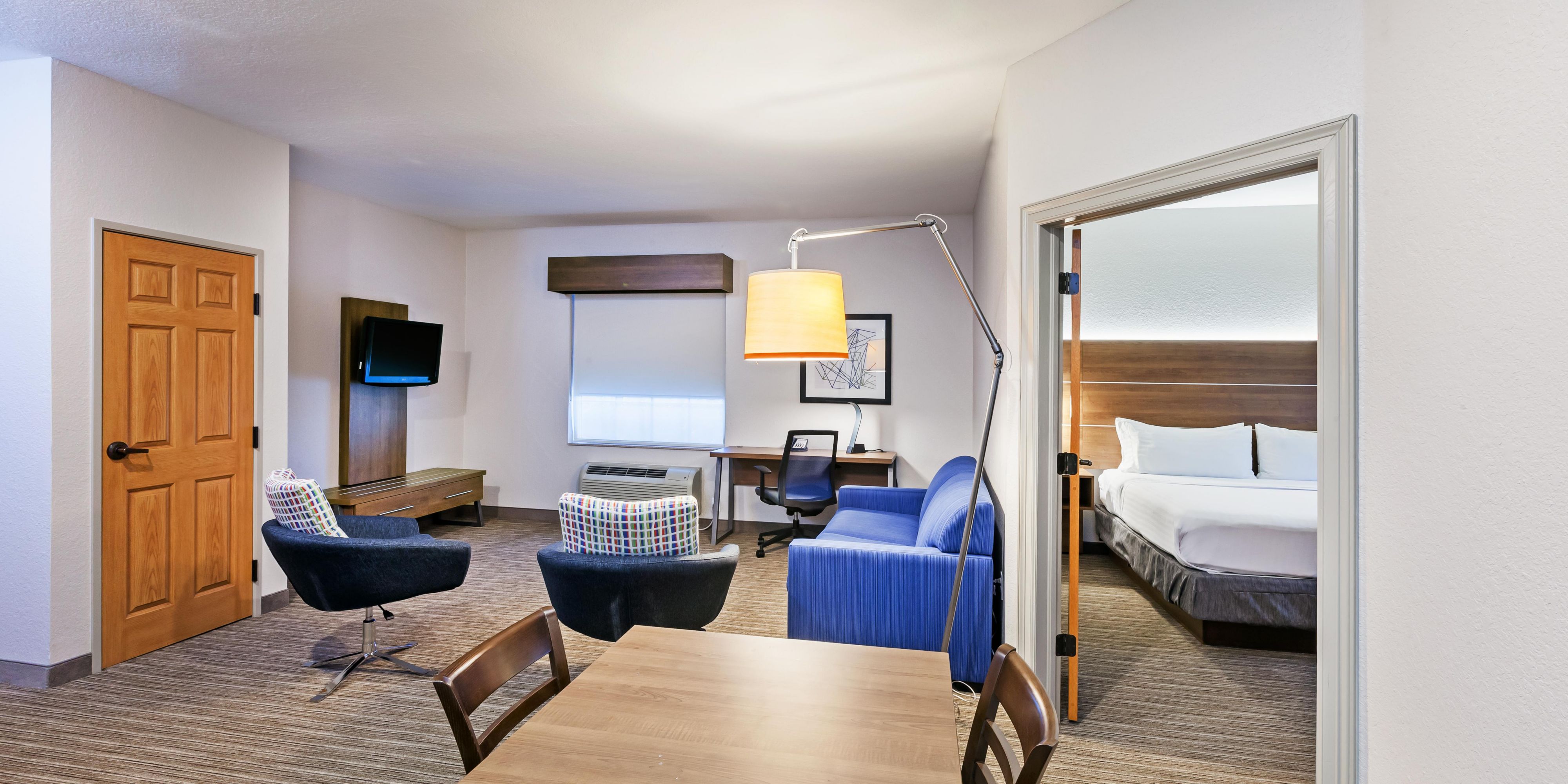 The Family Suite features an open floor plan offering a dining and living room with TV and kitchenette combo with mini fridge, microwave, and Keurig Coffee Maker. The king bed is located in its own room with closing doors and TV.  A separate room features twin size bunk beds that flows with the open floor plan, with a TV and Sony PlayStation. 