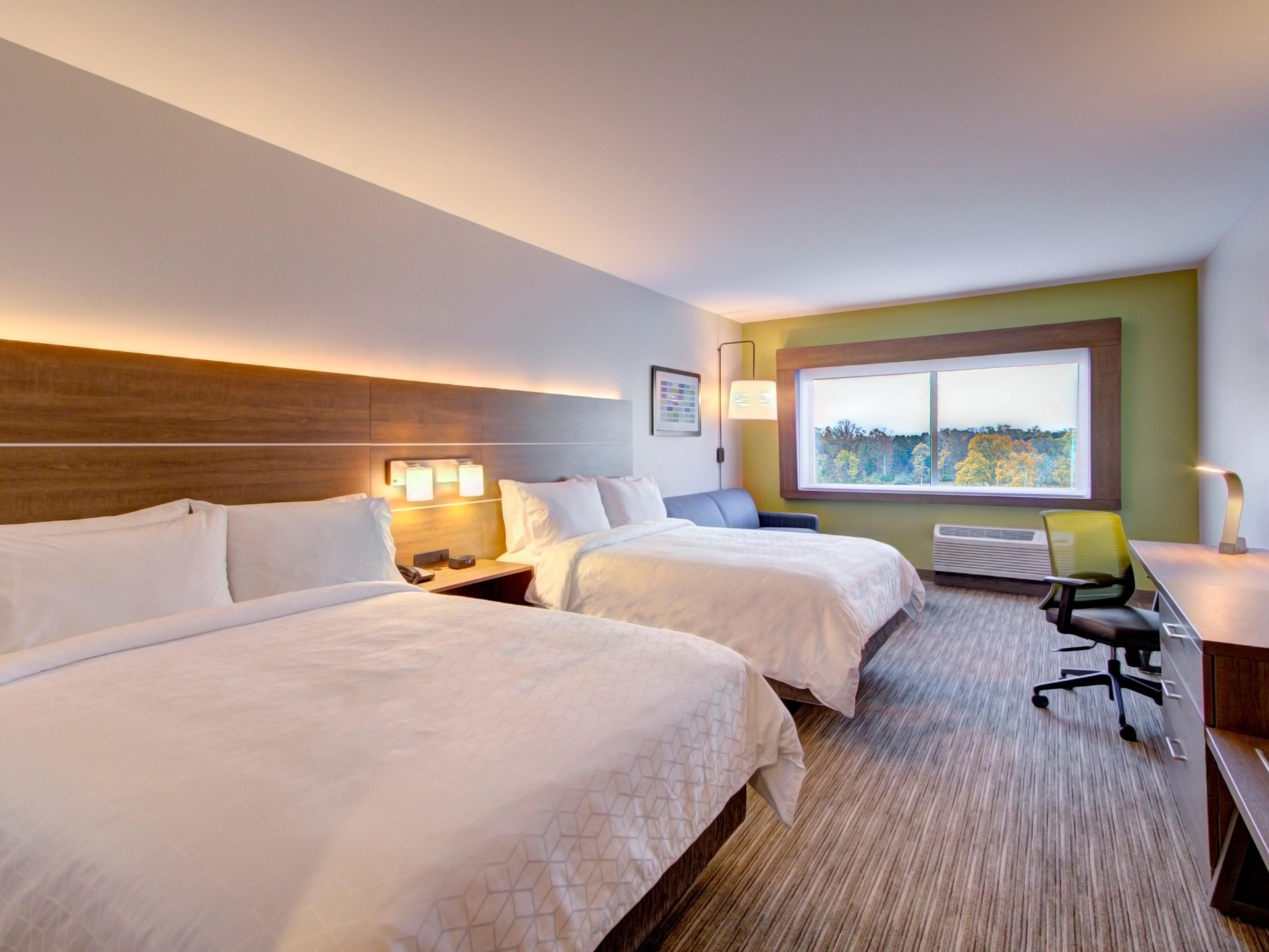 Two queen room at Holiday Inn Express Charlotte Southwest with premium white bedding and a wood-paneled headboard