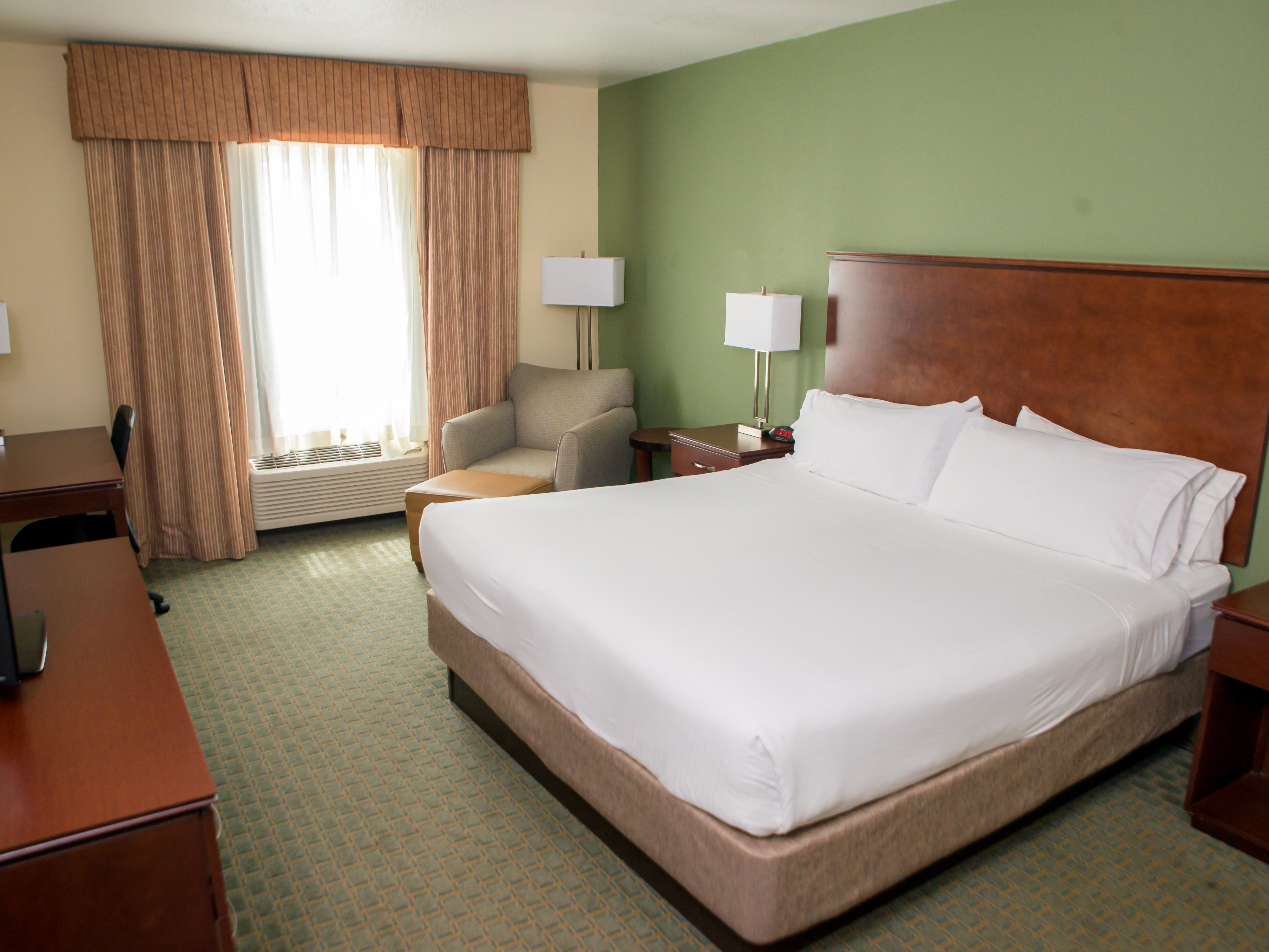 Each room features plush bedding and a lounge area.