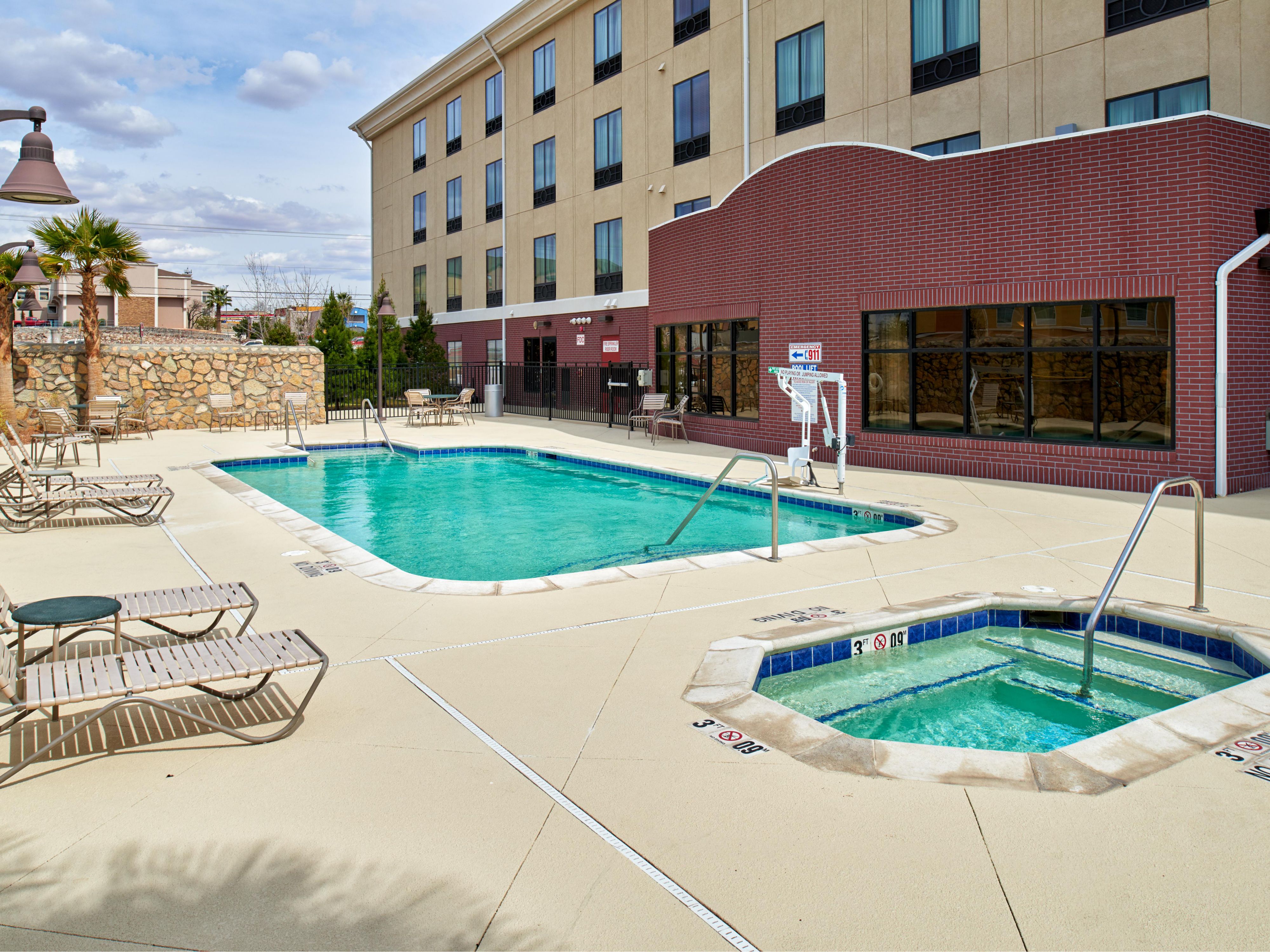 Outdoor swimming pool with hot tub with lounge chairs for relaxing