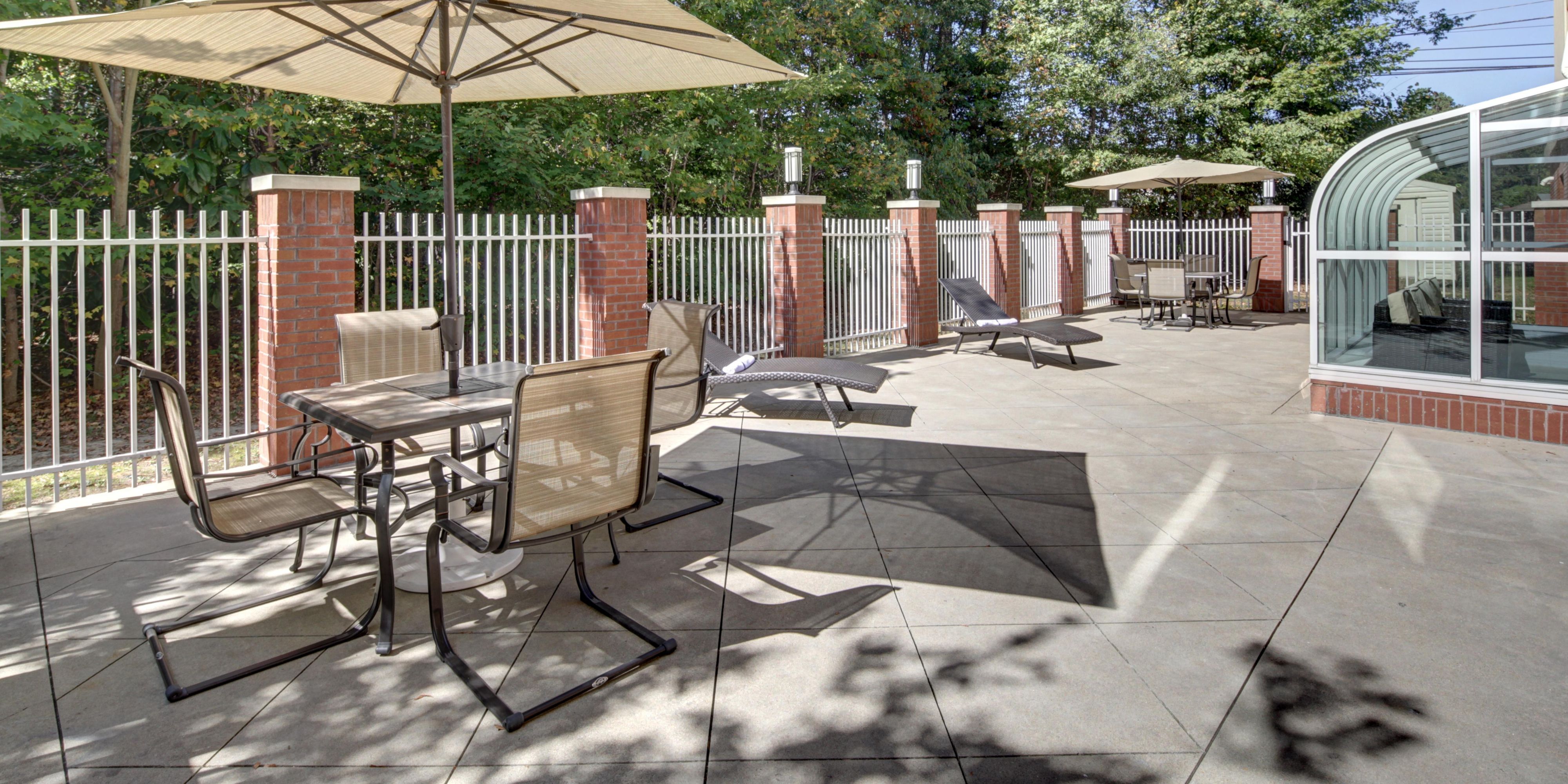 Very Calming Space that oversees a wooded area with 8 benches and tables and chairs.