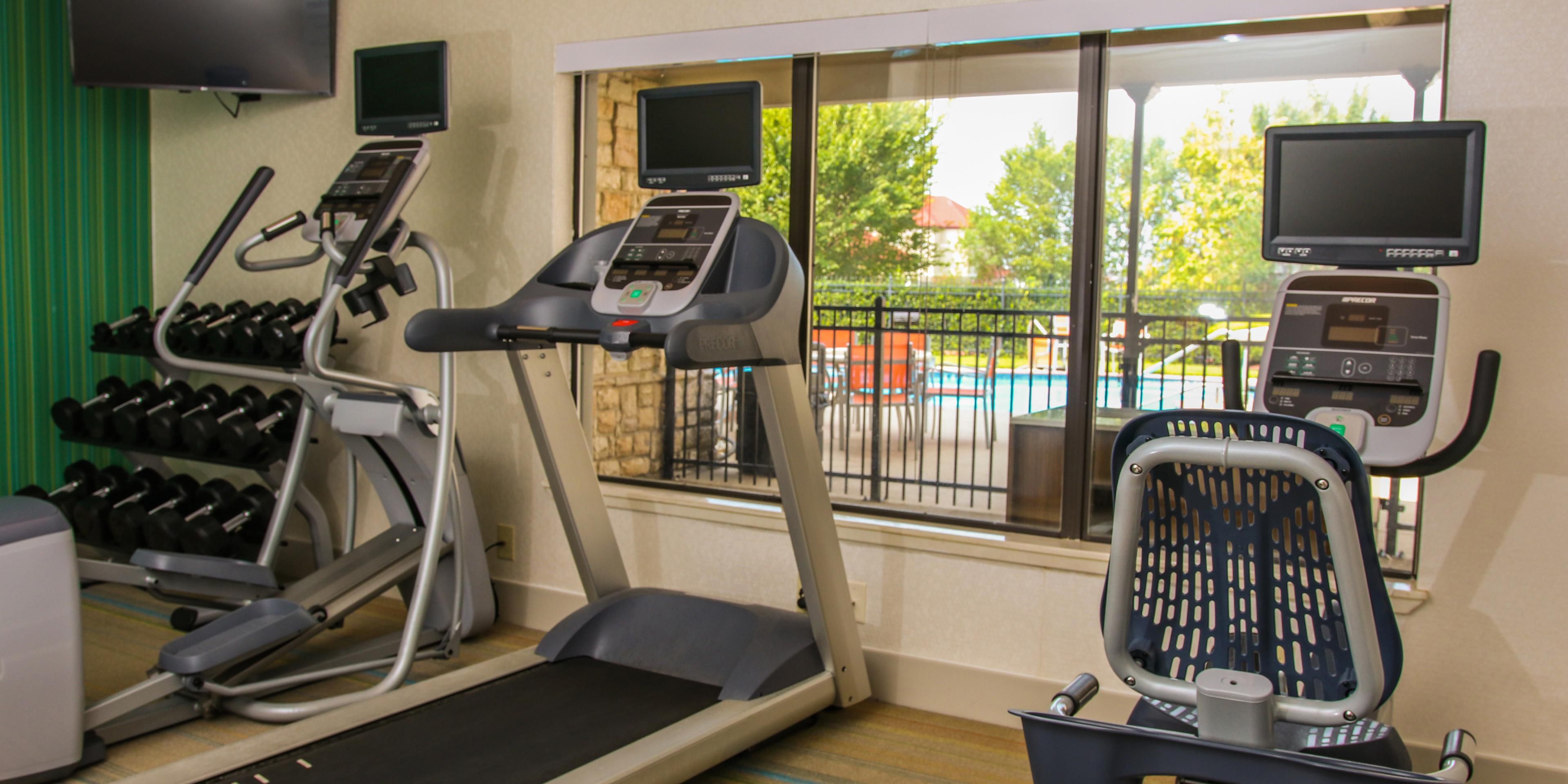 Fitness Center with treadmill looking out to the pool, exercise bike, cardio bike, dumbbells, stretch rope,  & yoga ball with mat.