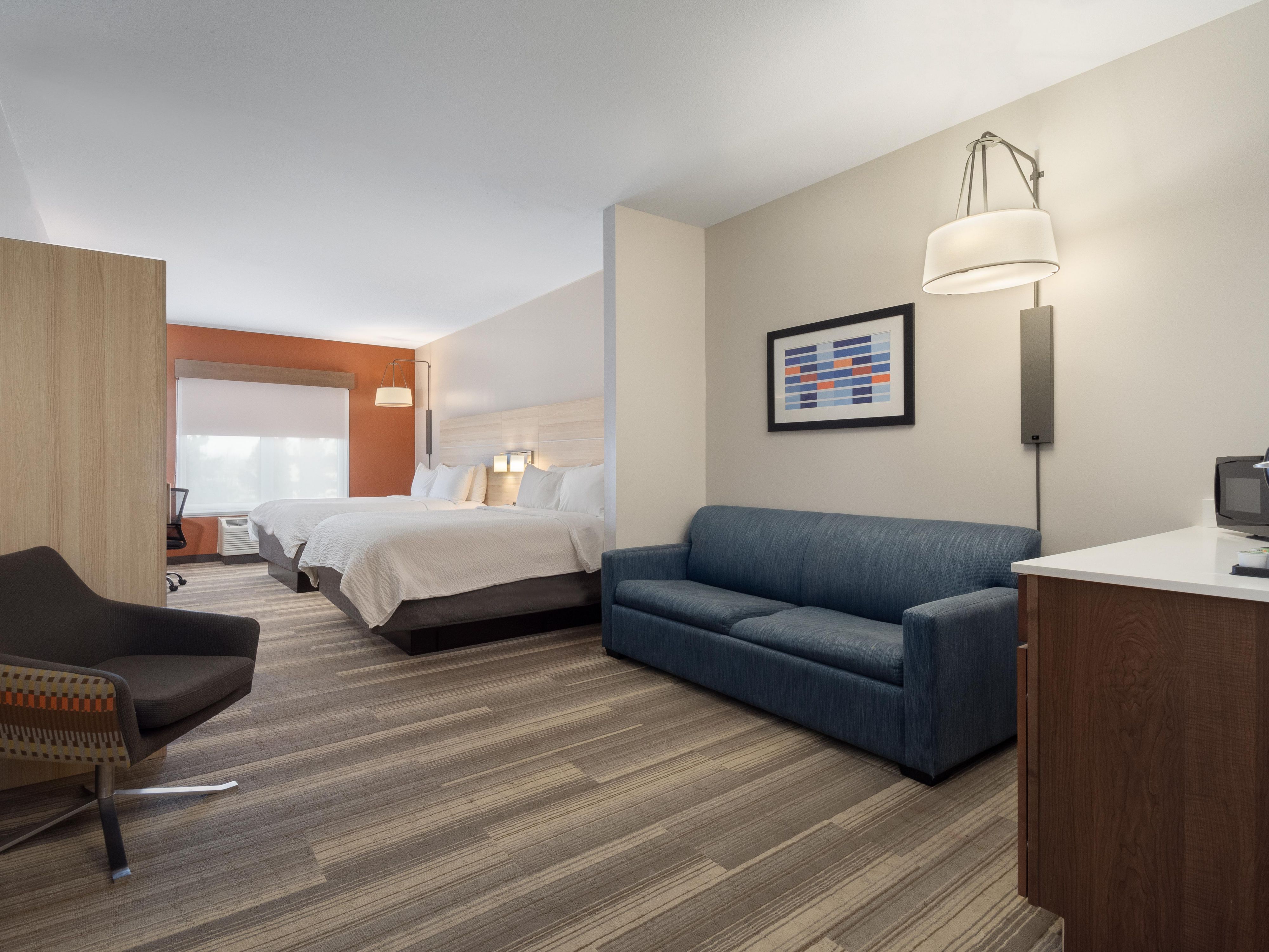 Habitación de invitados con dos camas queen y sofá cama