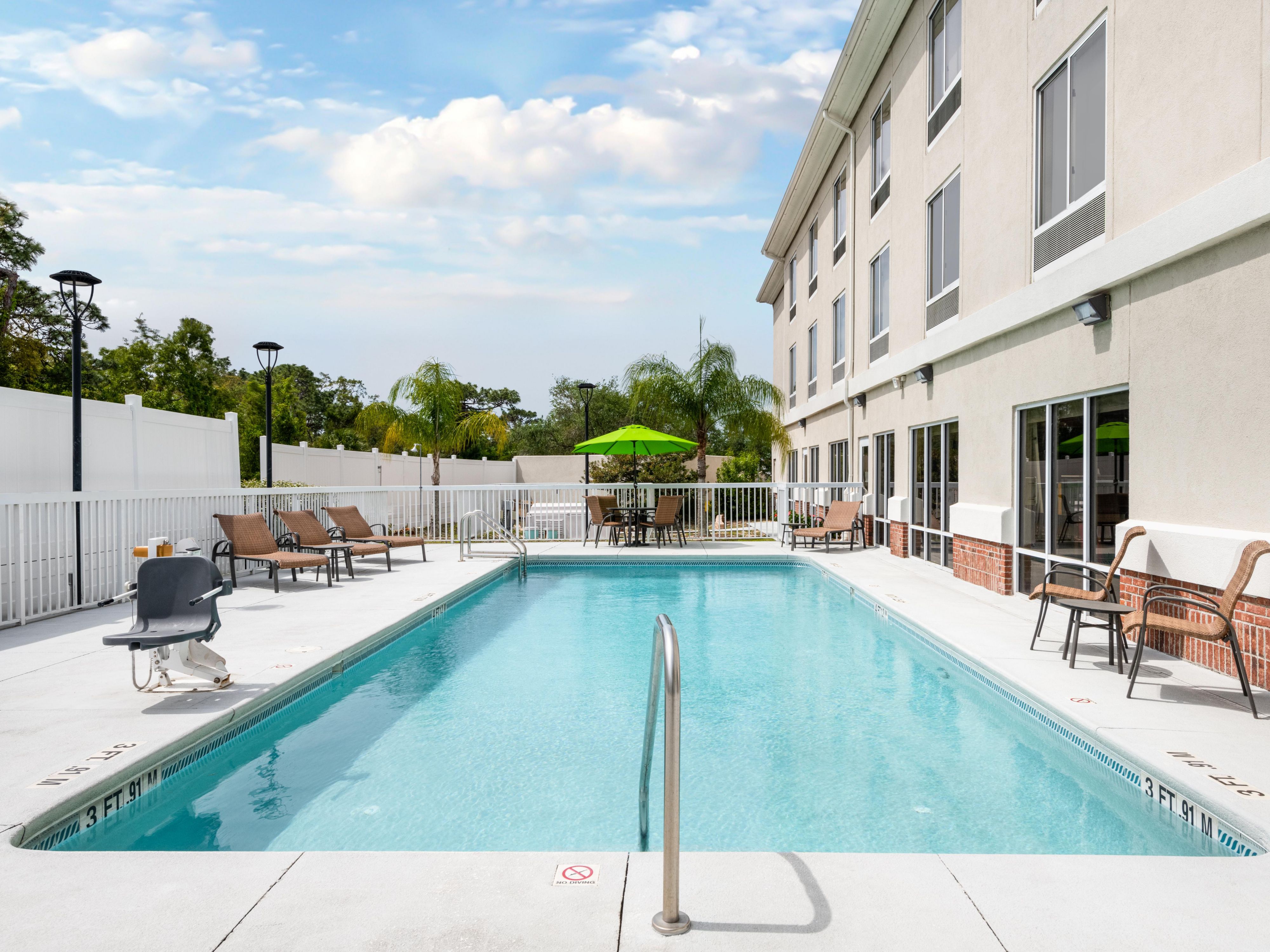 Outdoor pool area with seating and umbrellas