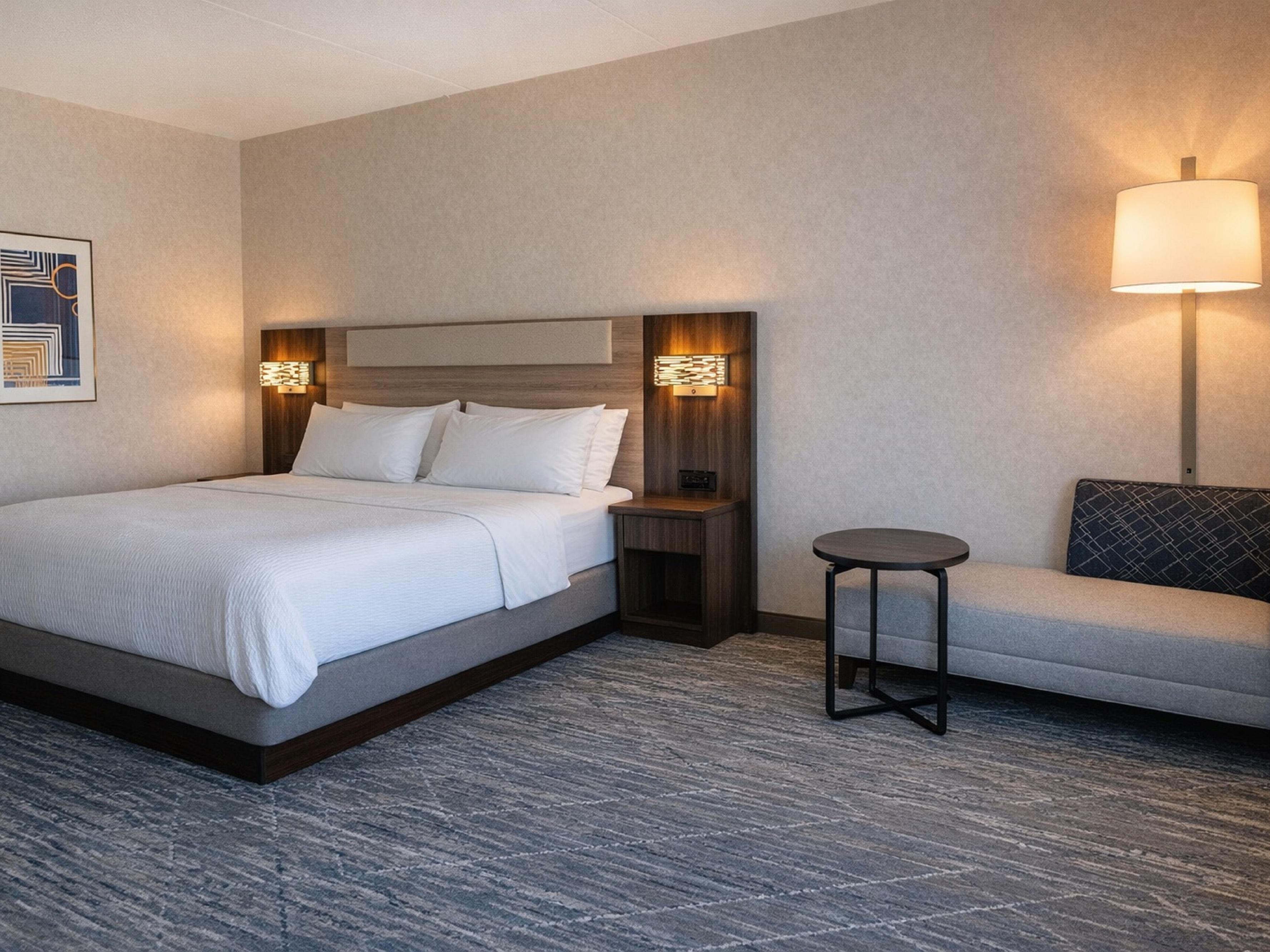 Rest in your spacious Timmins hotel room with a lounge chair.