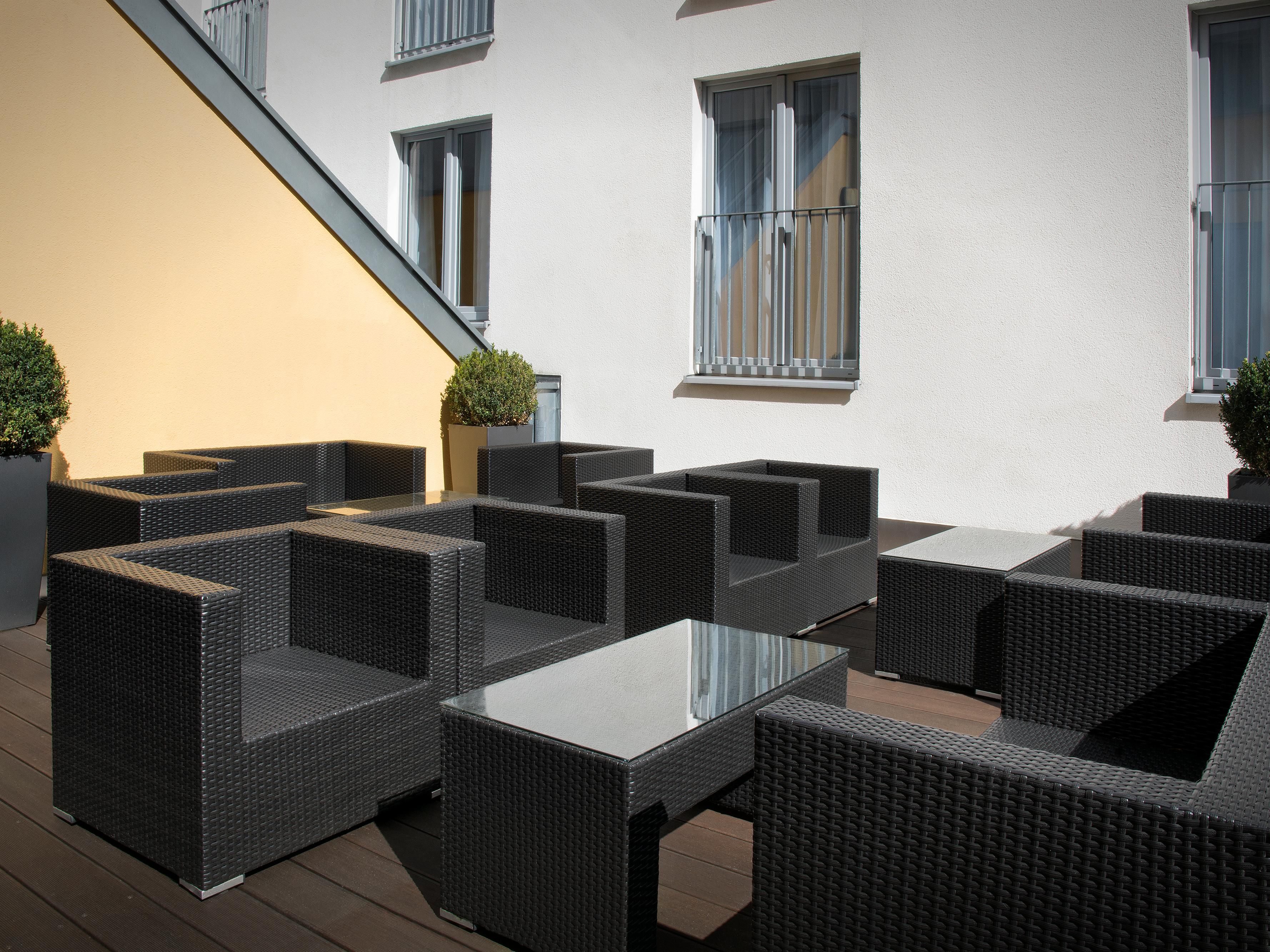 A sunny balcony with stylish seating, ideal for after-work drinks.