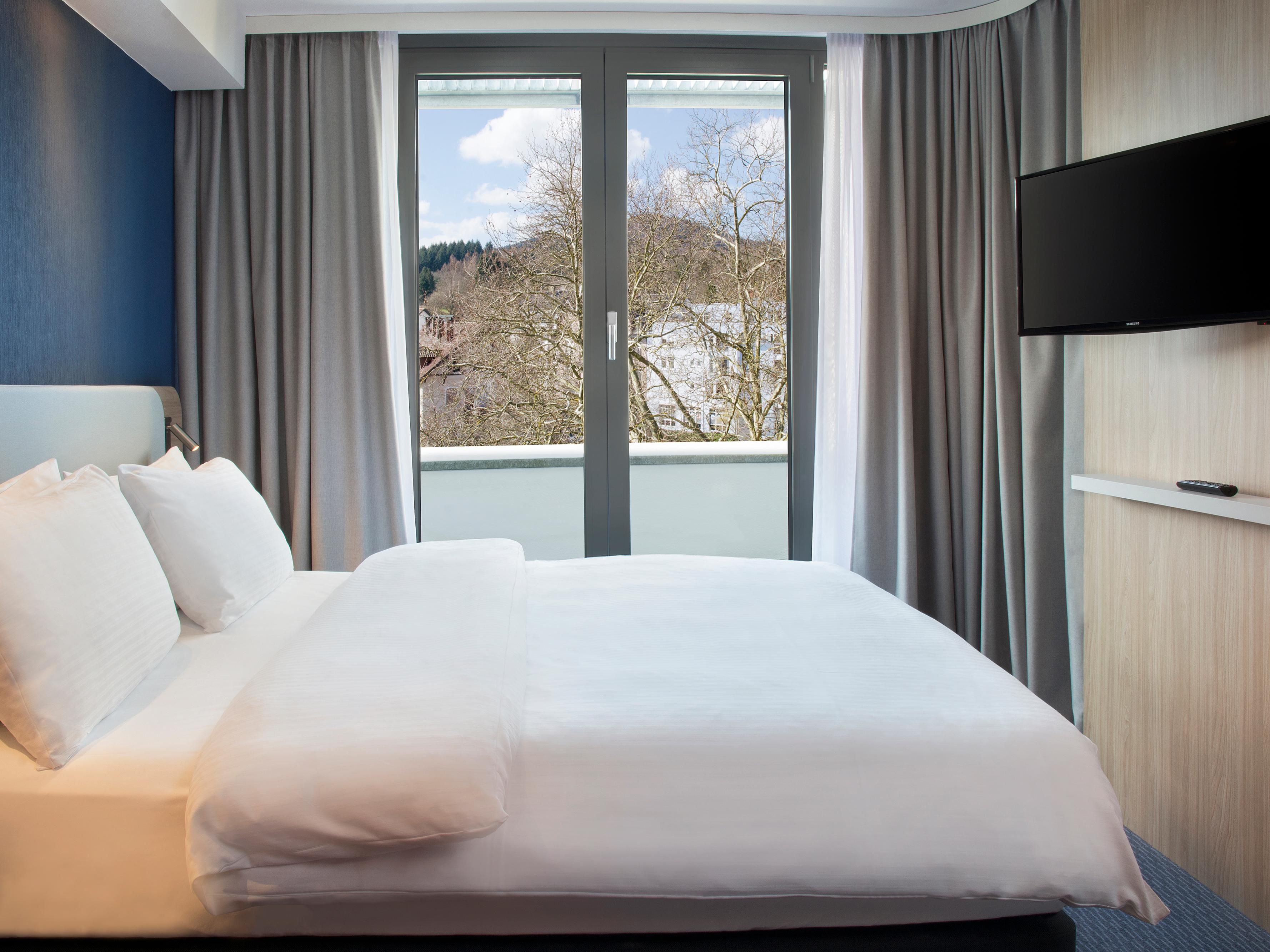 A stylish room with floor-to-ceiling windows and city views.