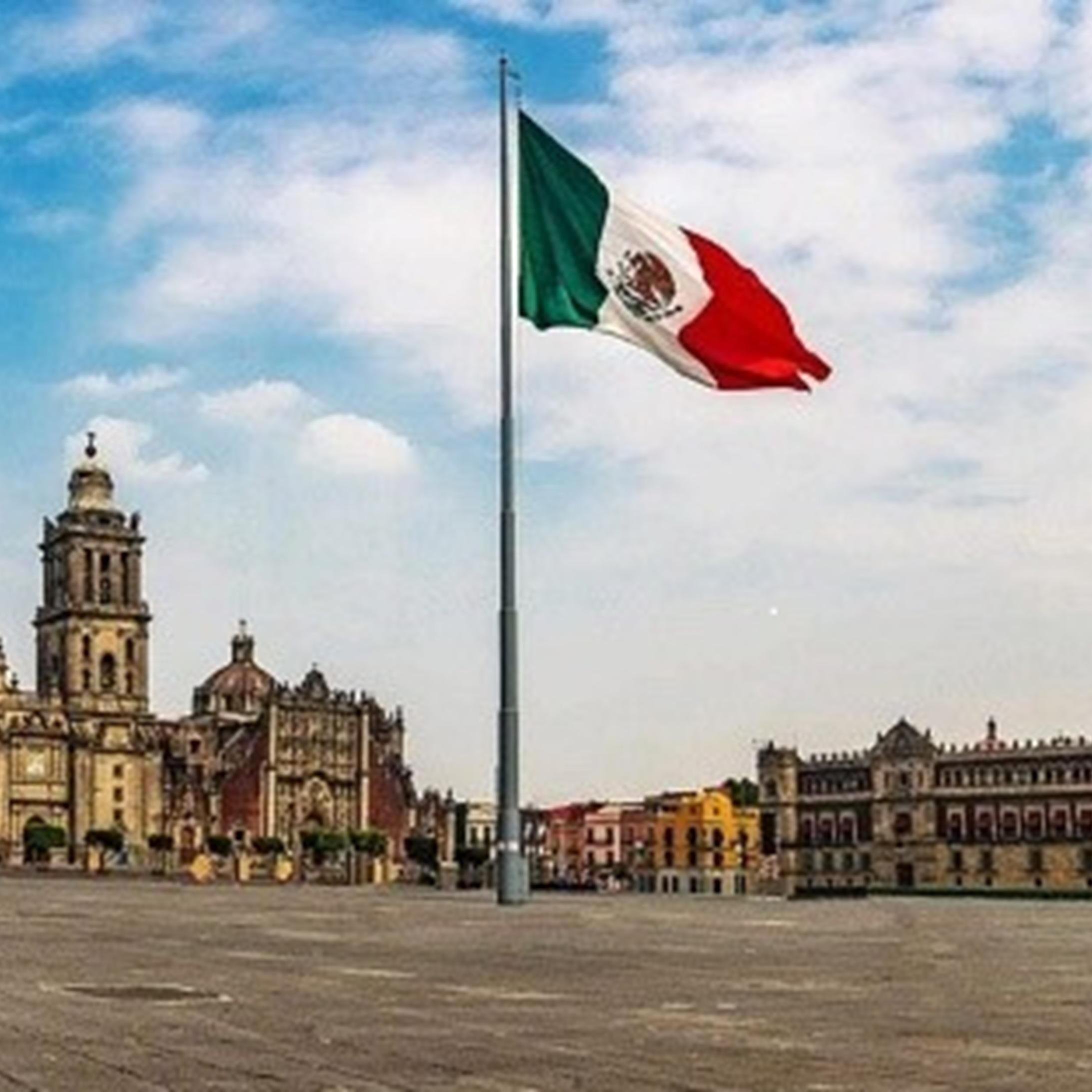 Mexican Flag waving in front of capital building in downtown Mexico City