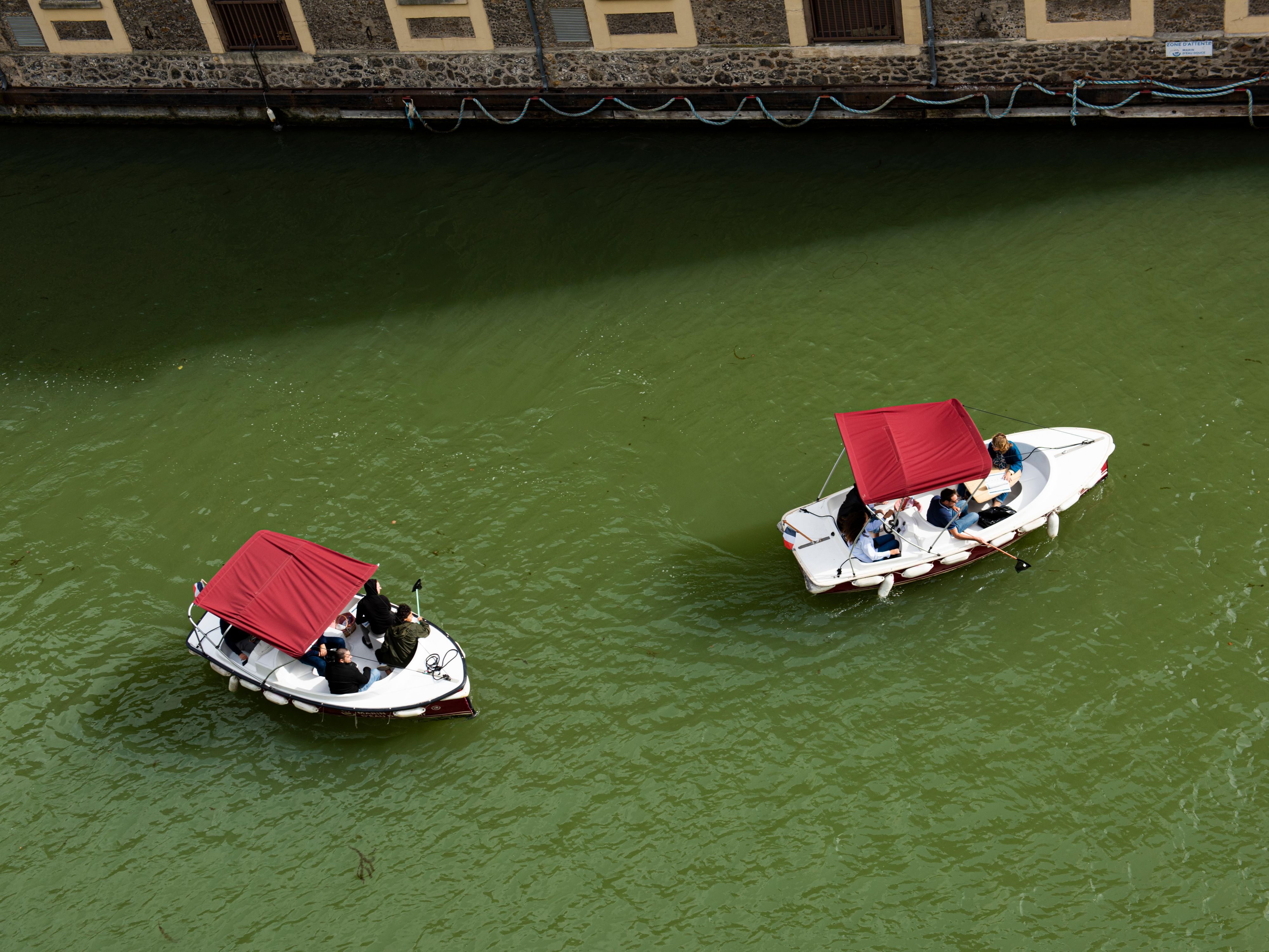Small green electric boat activity on the canal