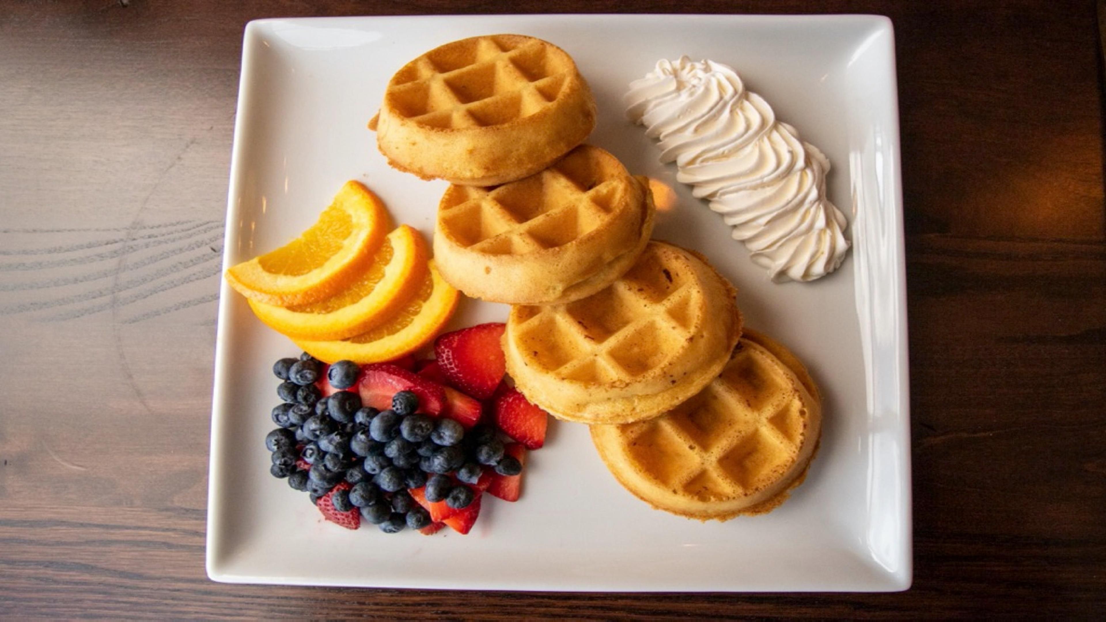 Waffles and fruit with whipped cream