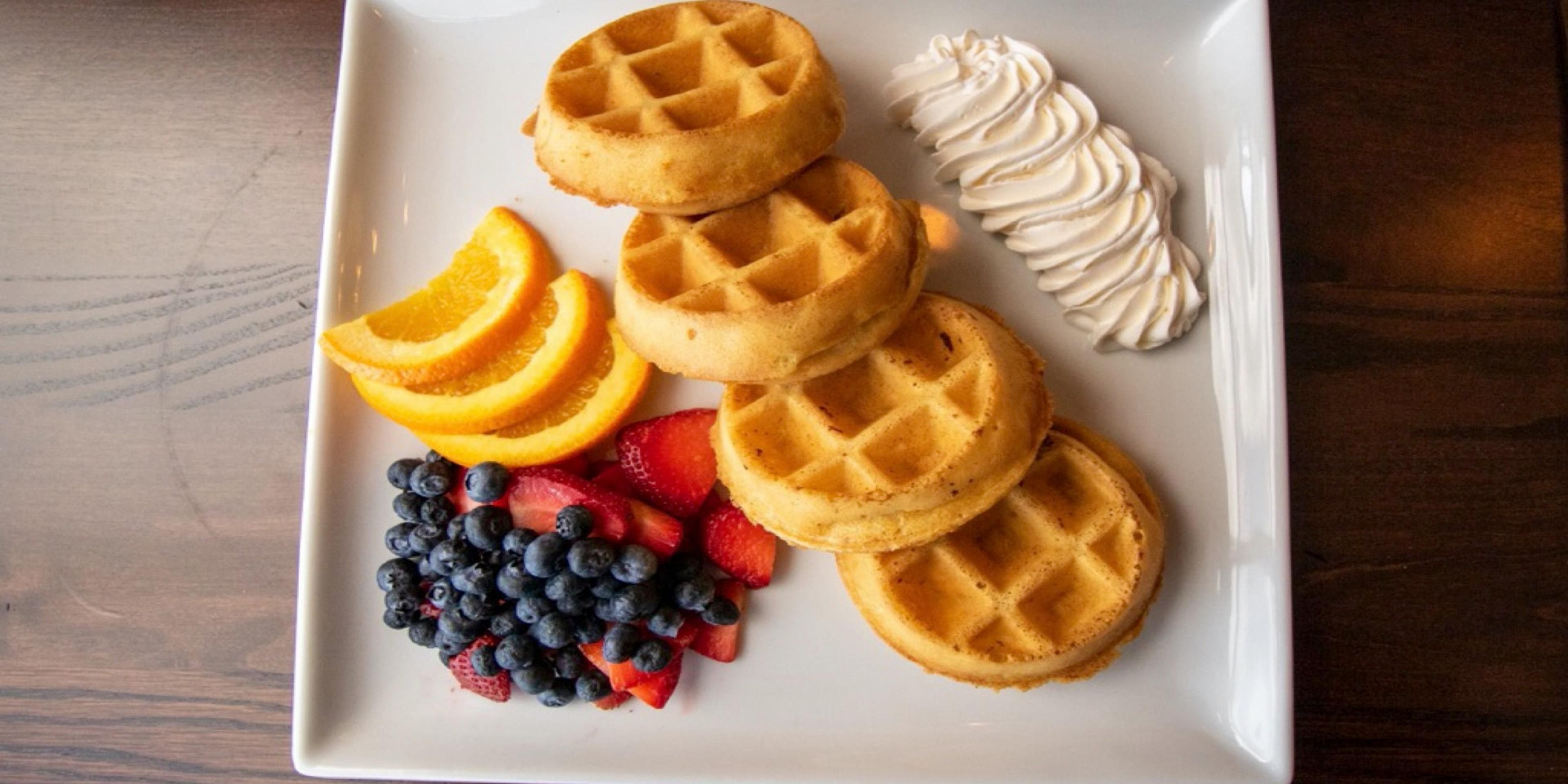 Waffles and fruit with whipped cream