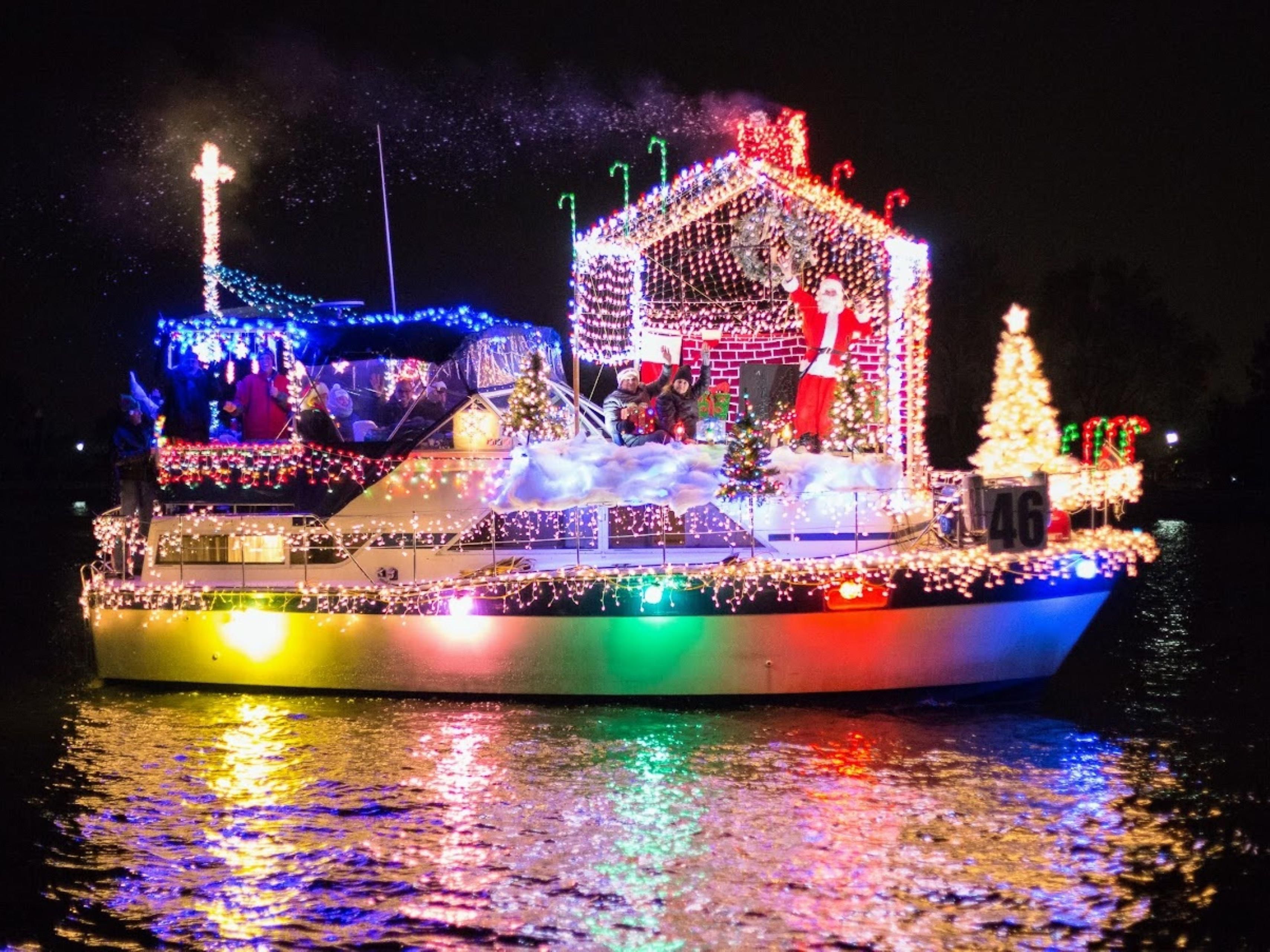 Boat decorated with colorful holiday lights during a nighttime parade