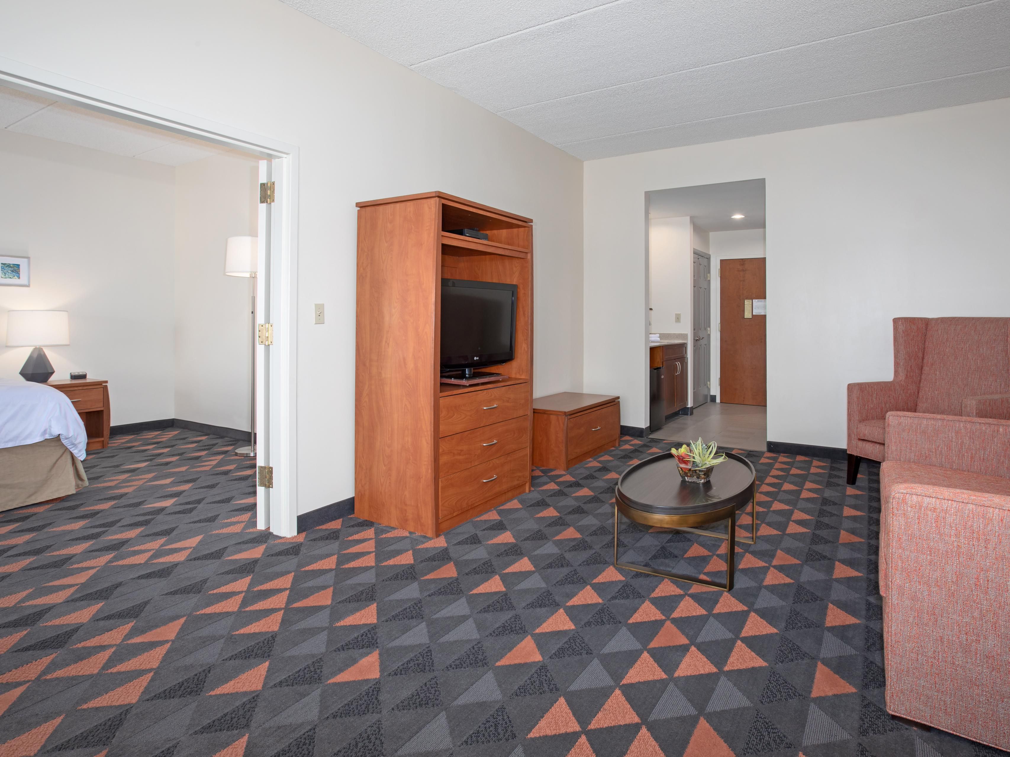 Experience comfort and convenience in our spacious two-room suites, featuring a king bed with crisp triple-sheeting and a separate living room with a sofa sleeper. Each suite offers a microwave, mini fridge, and Keurig, plus a Jacuzzi tub. Stay productive at a work desk, connected with free Wi-Fi, and enjoy a home-away-from-home feel.
