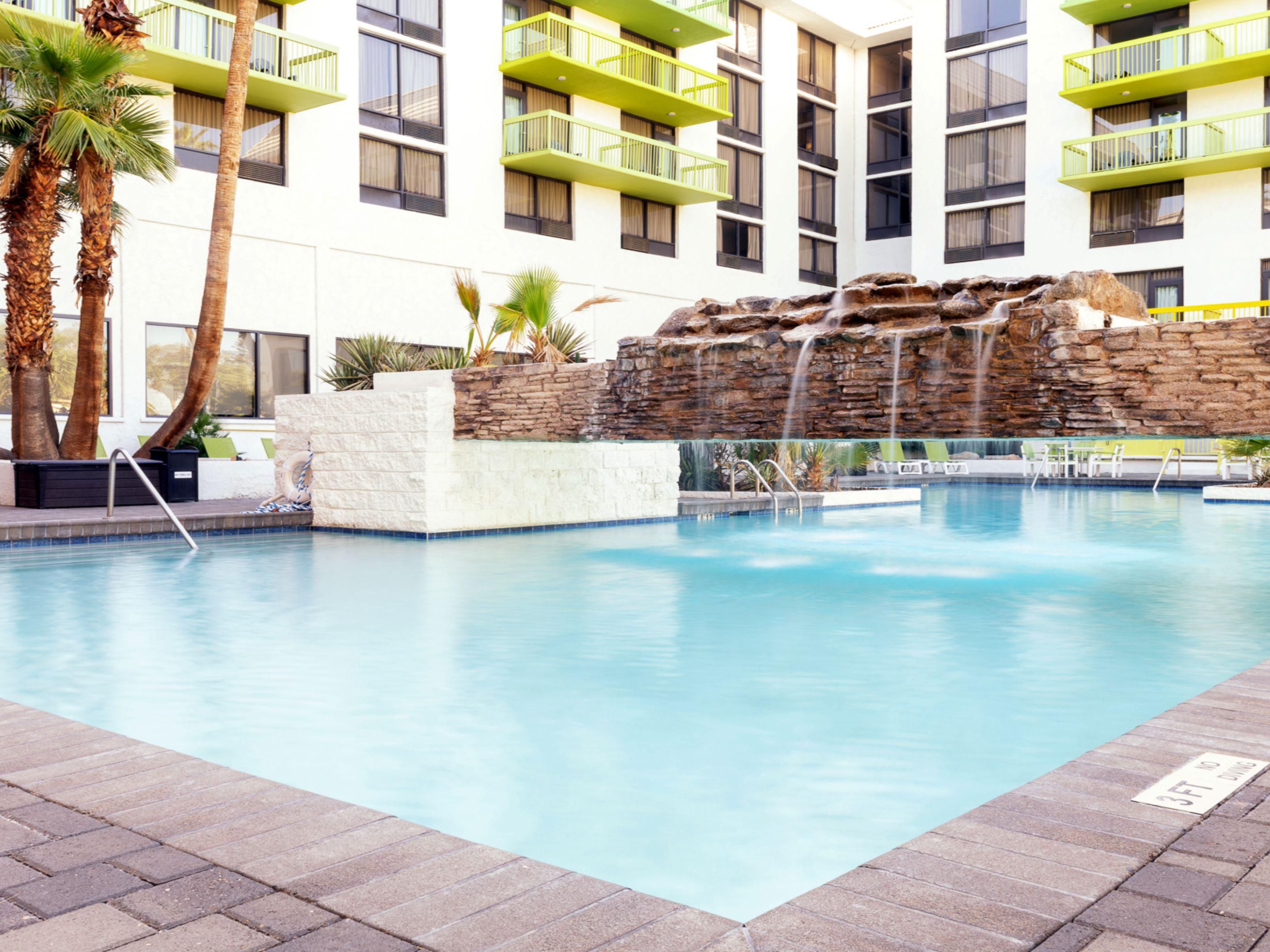 Enjoy top amenities at our hotel near Mesa Gateway Airport, featuring a large outdoor pool and whirlpool with a waterfall, patio, and fire pits. Dine at Cactus Kitchen + Bar, where kids under 12 eat free, or grab a quick bite from our 24/7 convenience shop. Stay active in our 24-hour Fitness Center and enjoy free parking and Wi-Fi during your stay.