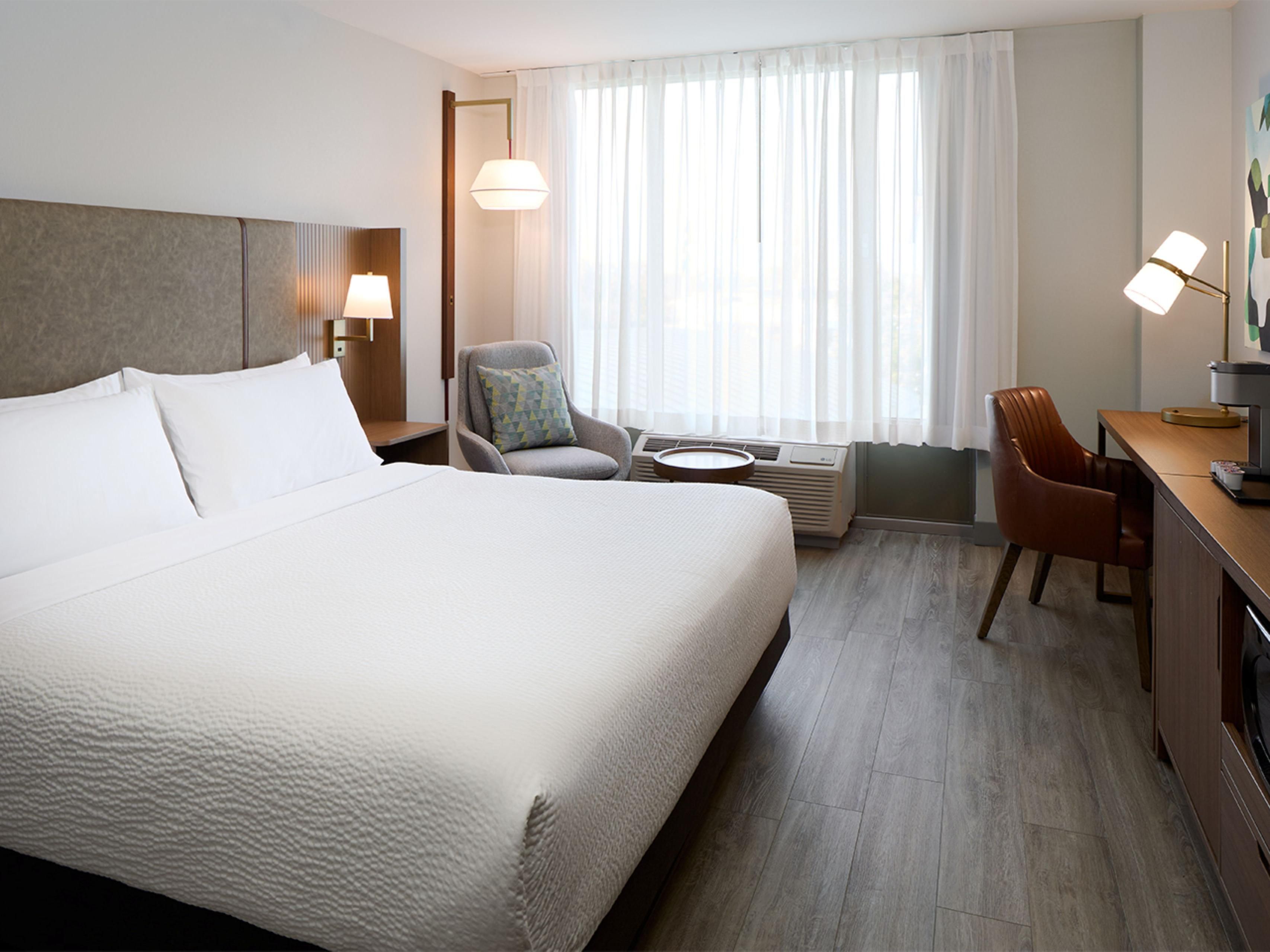 Choisissez entre une chambre standard ou une suite junior, toutes spacieuses et bien équipées : literie confortable, Wi-Fi gratuit, télé à écran plat, coin travail, mini-frigo et cafetière. Les suites offrent également une cuisinette, un salon séparé et un espace de travail élargi pour encore plus de confort.
