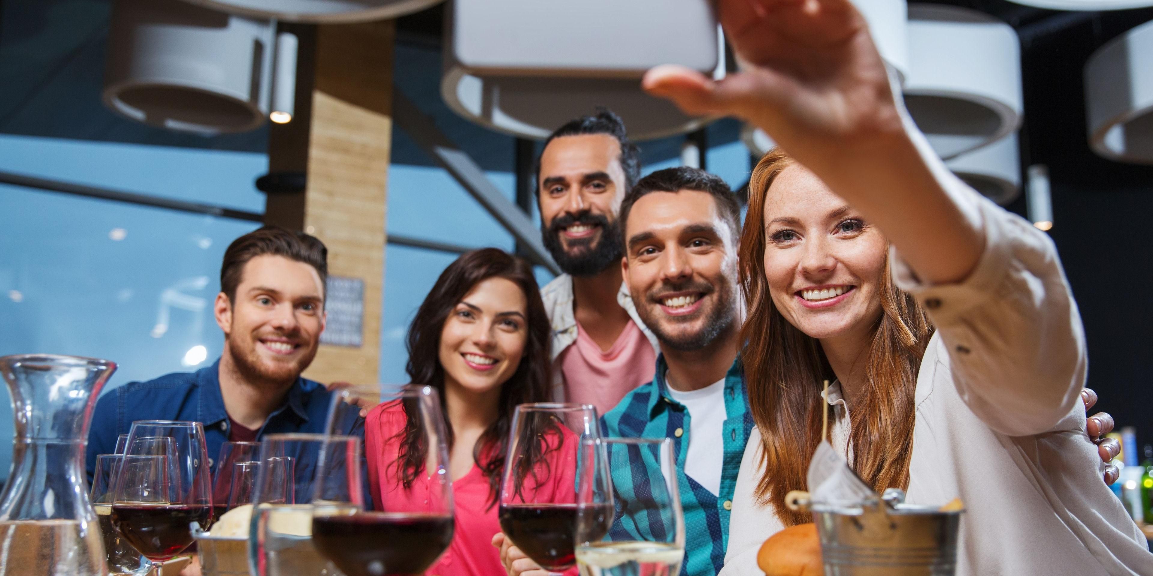Frinds taking selfie over burgers and wine