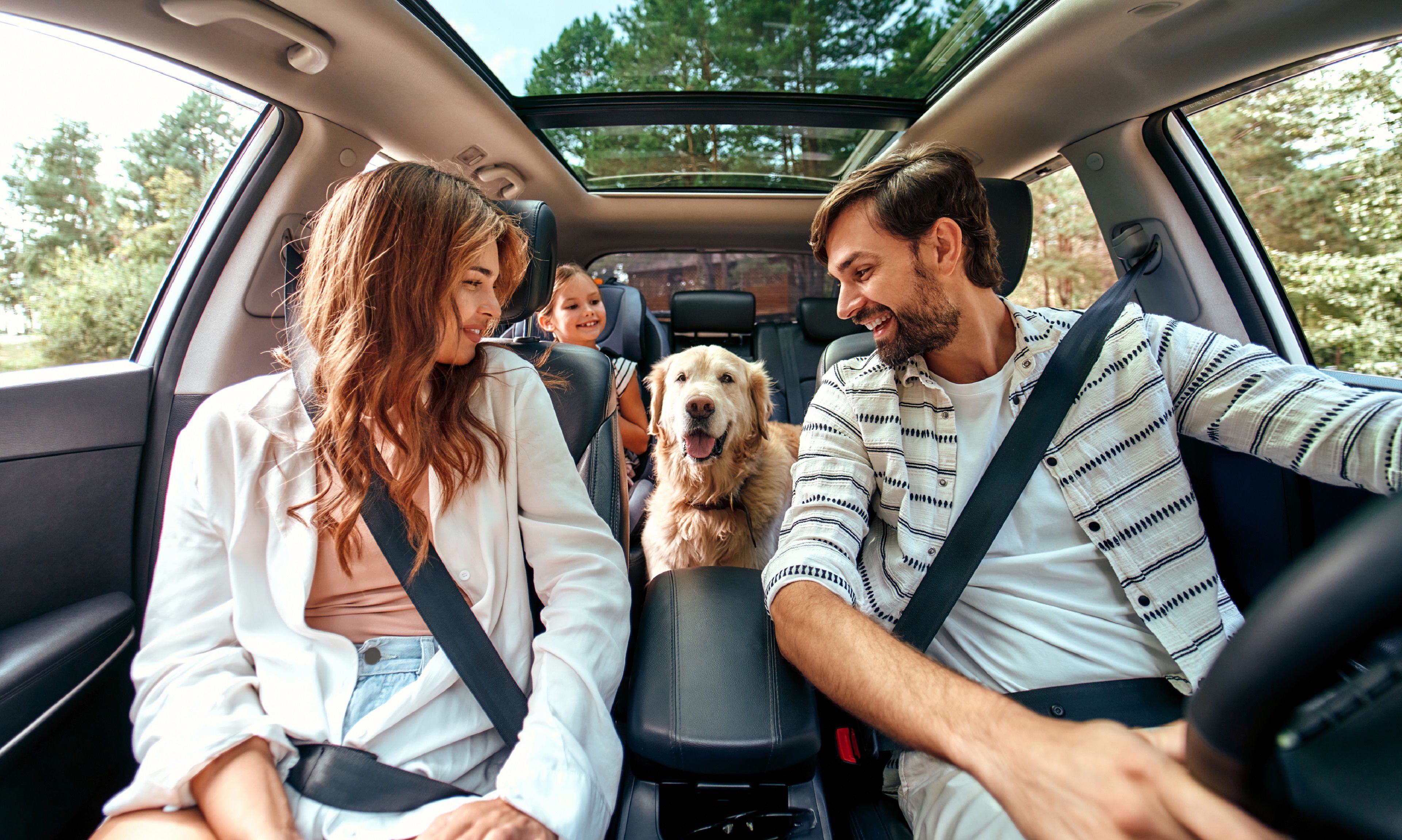 Family in the car with dog
