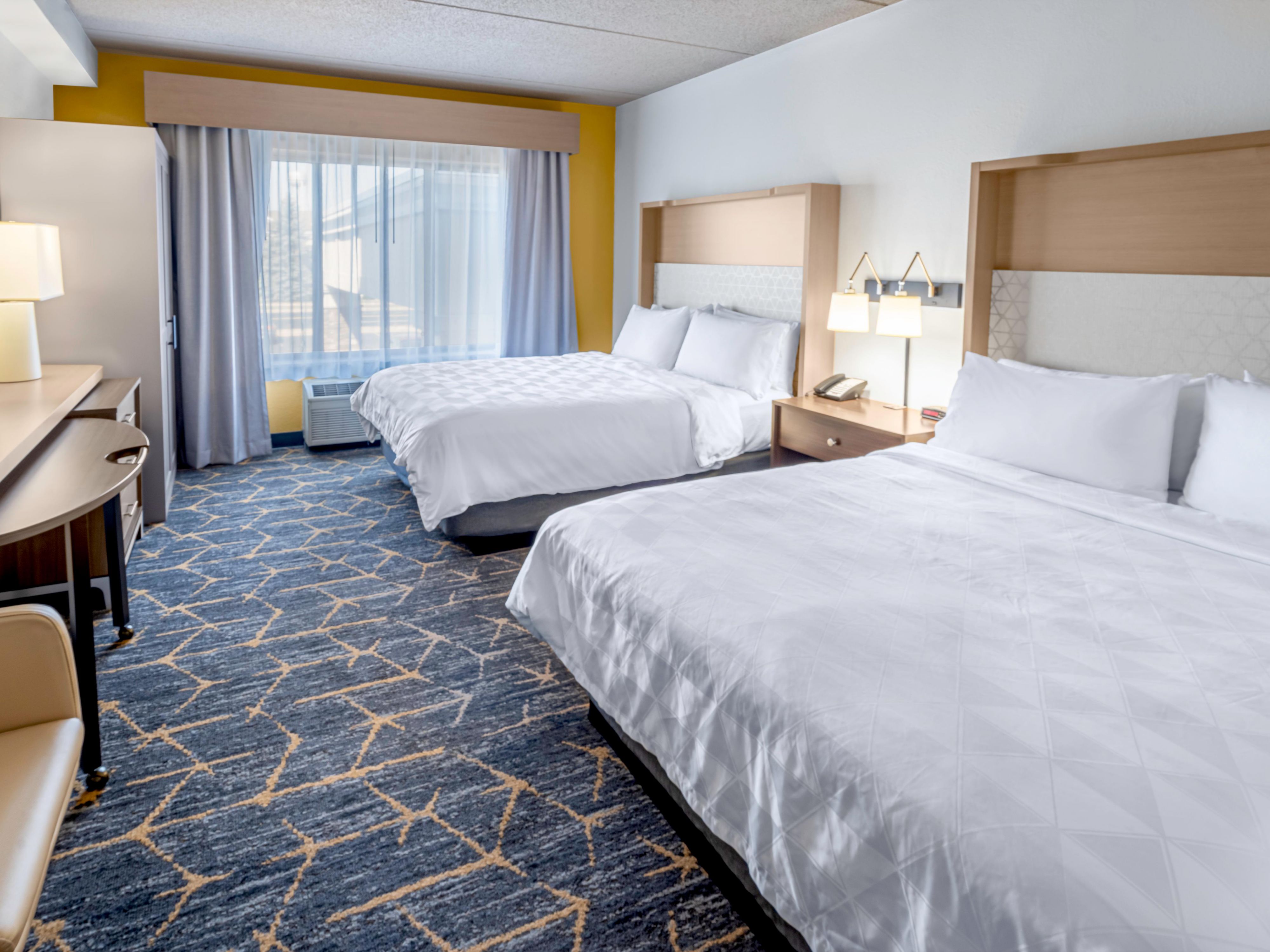 Our two queen bed suite welcomes you with fluffy white sheets
