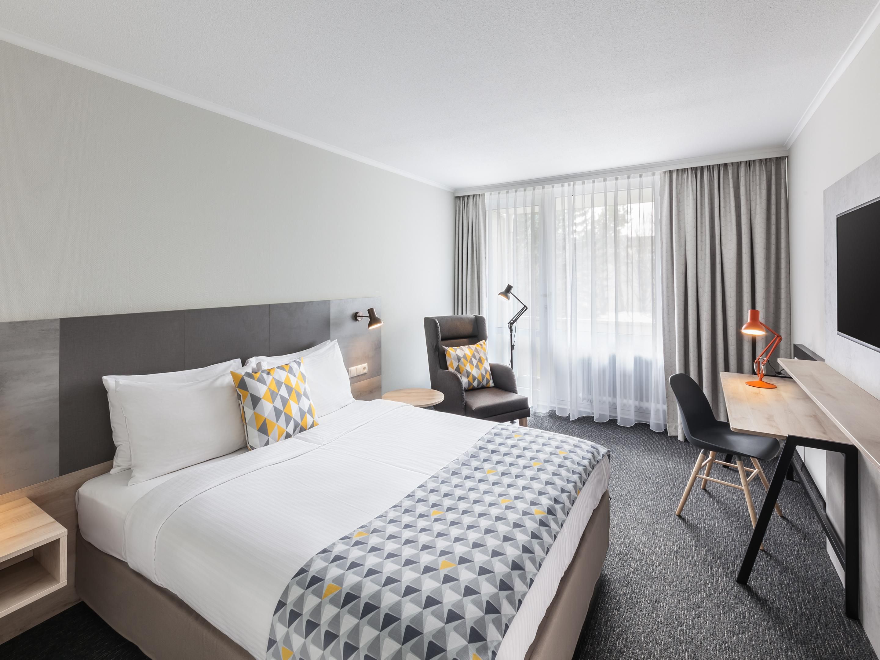 A spacious Holiday Inn standard room with a private balcony.
