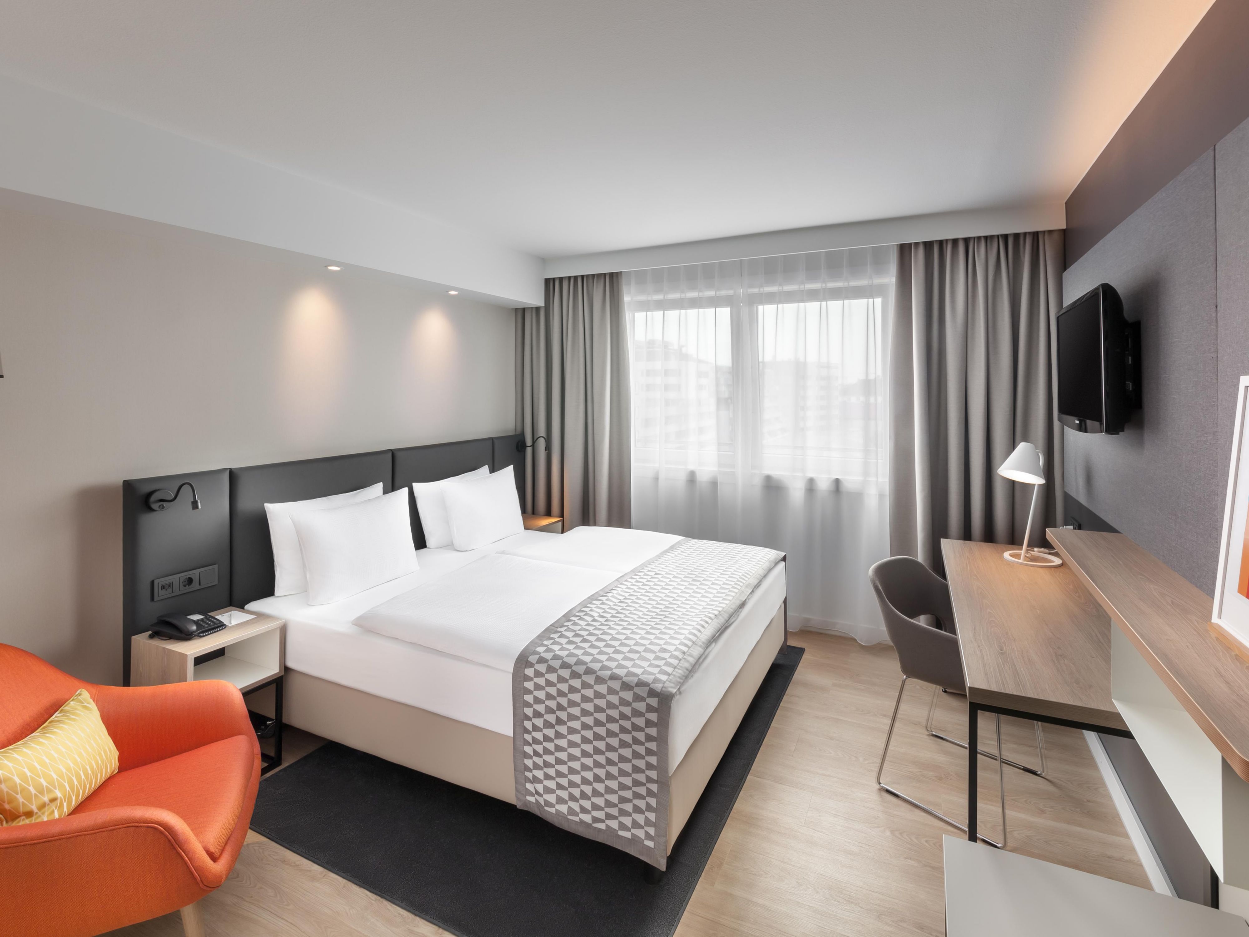 A double bed room with a pillow menu and blackout curtains.