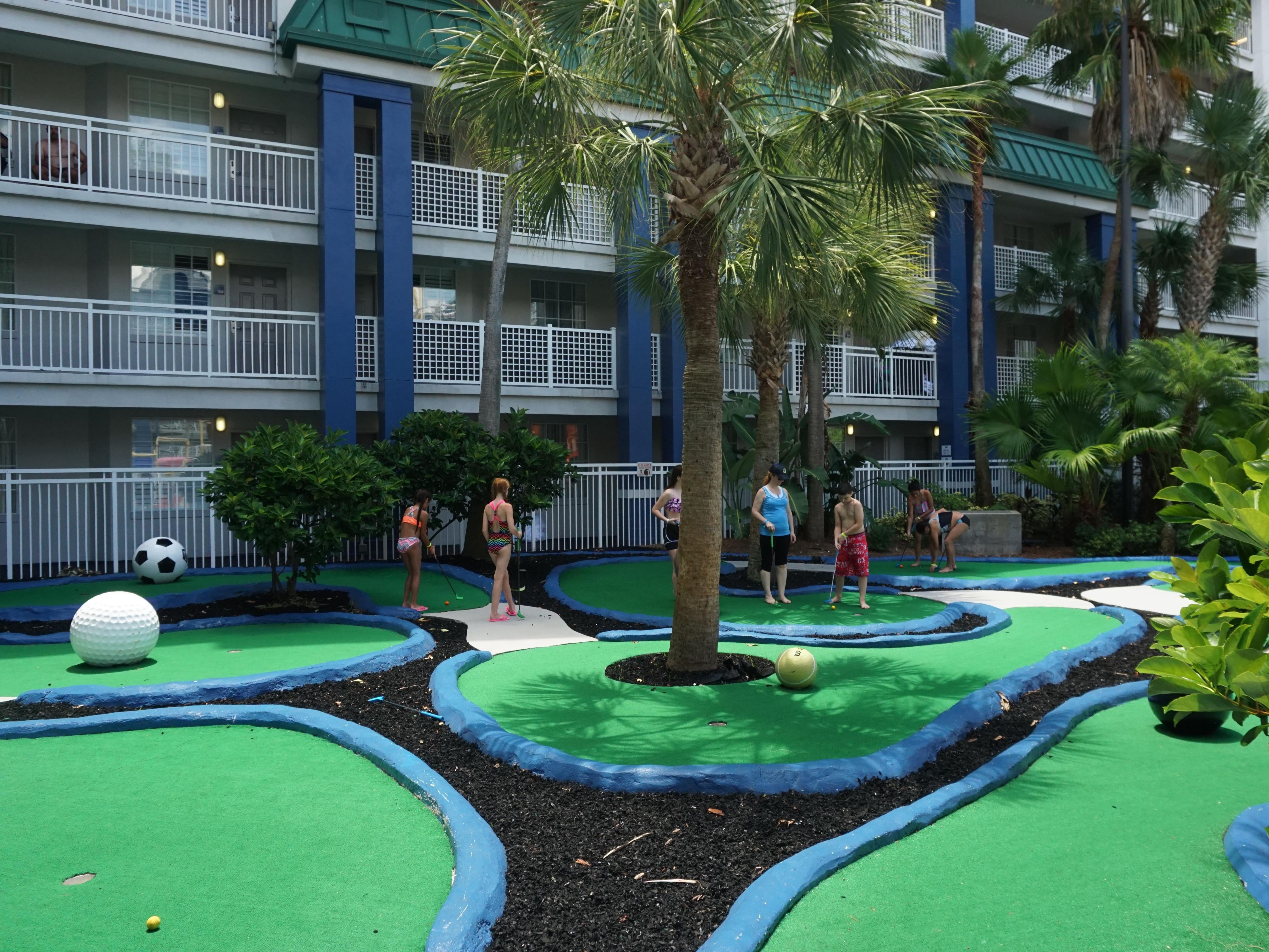 Family playing miniature golf on property