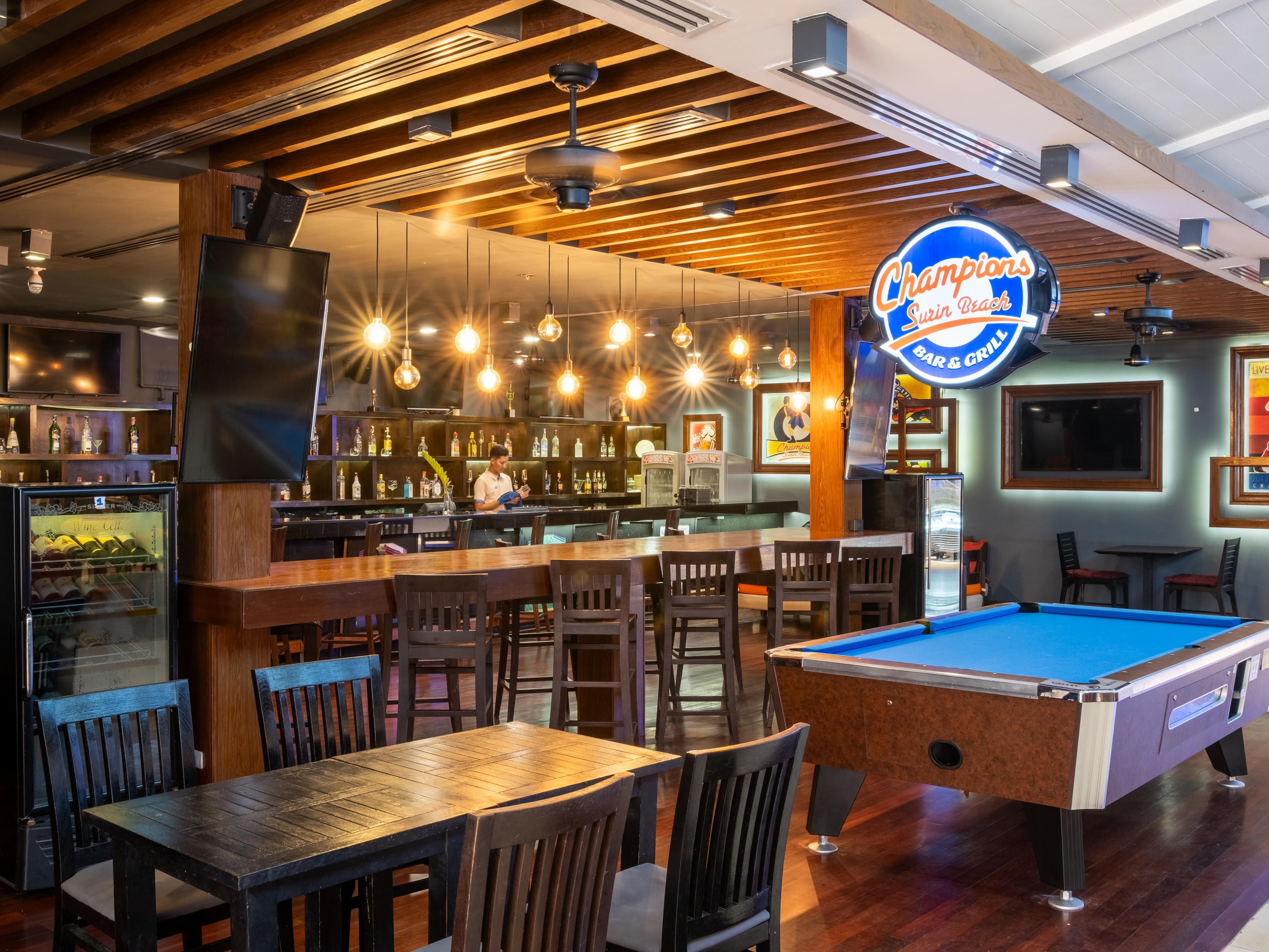 Join the excitement at Champions Sports Bar, Phuket’s go-to spot for sports lovers! Cheer for your favorite team with live broadcasts of sporting events from around the world, while enjoying a cold beer and tasty snacks.