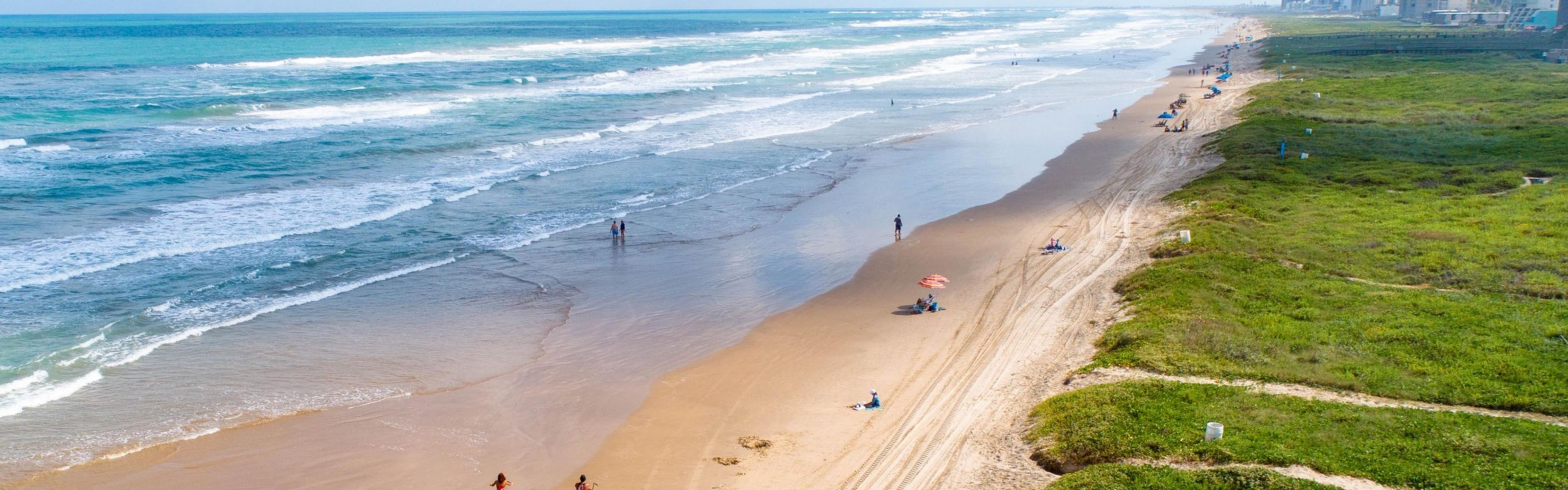 South Padre Island shoreline with waves and beachfront hotels.