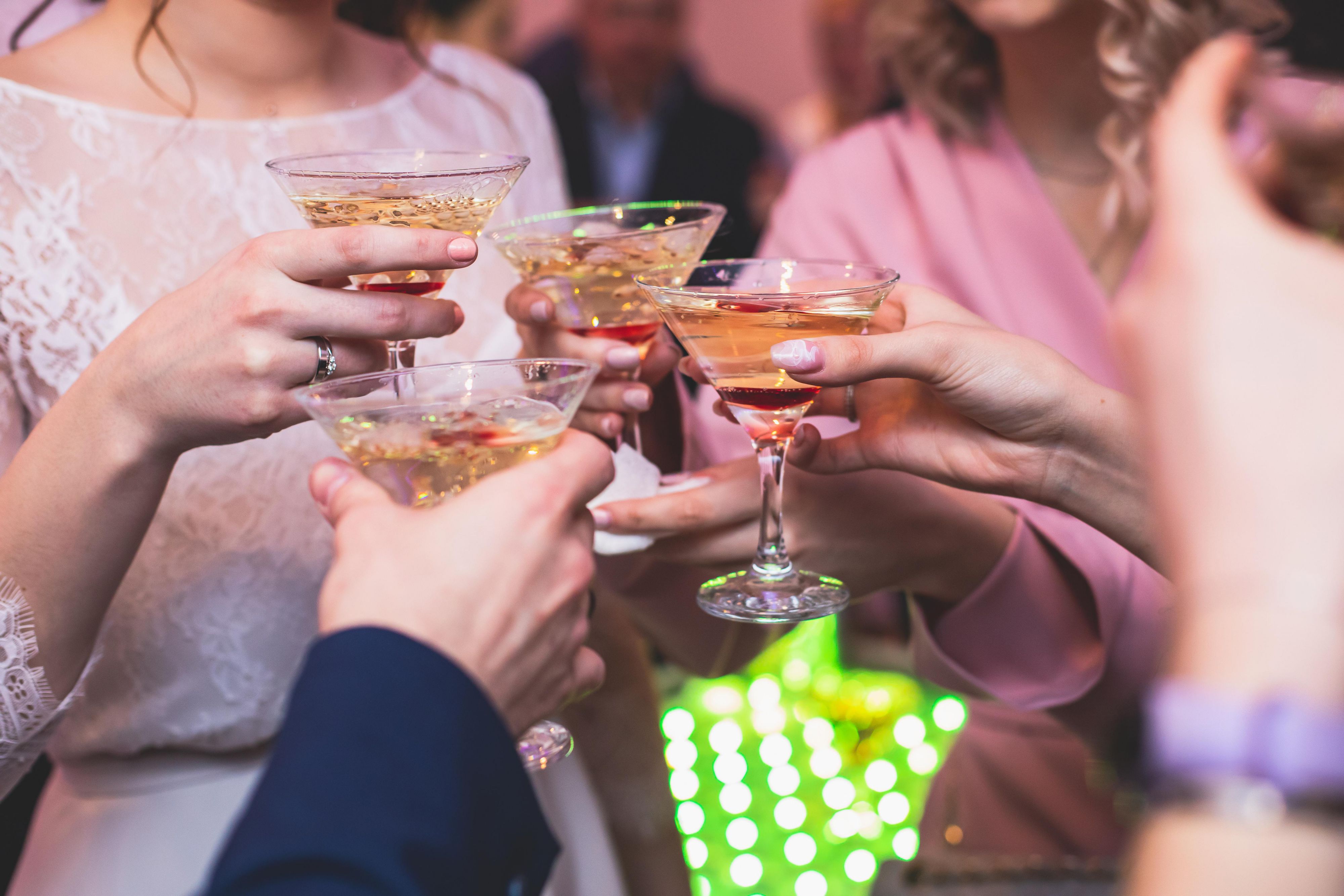 Group of friends raising their glasses in a toast at a social event, celebrating together.