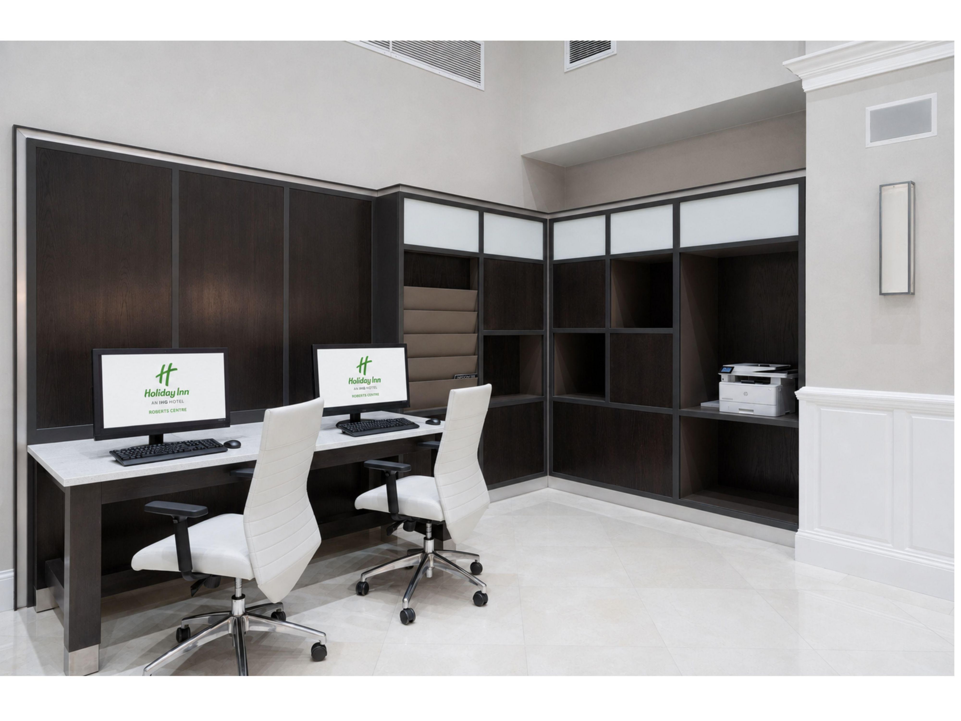 Centro de negocios con estaciones de trabajo e impresora.