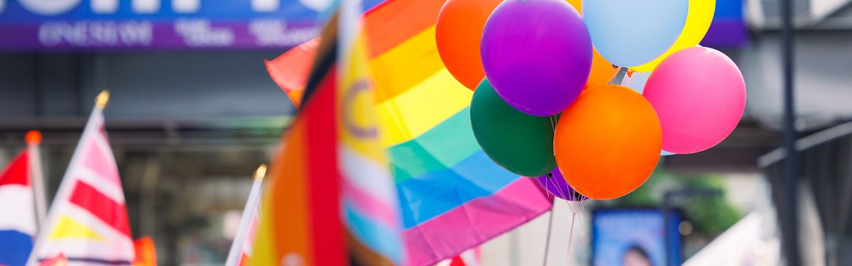 Colorful pride celebration with rainbow flags and vibrant balloons.