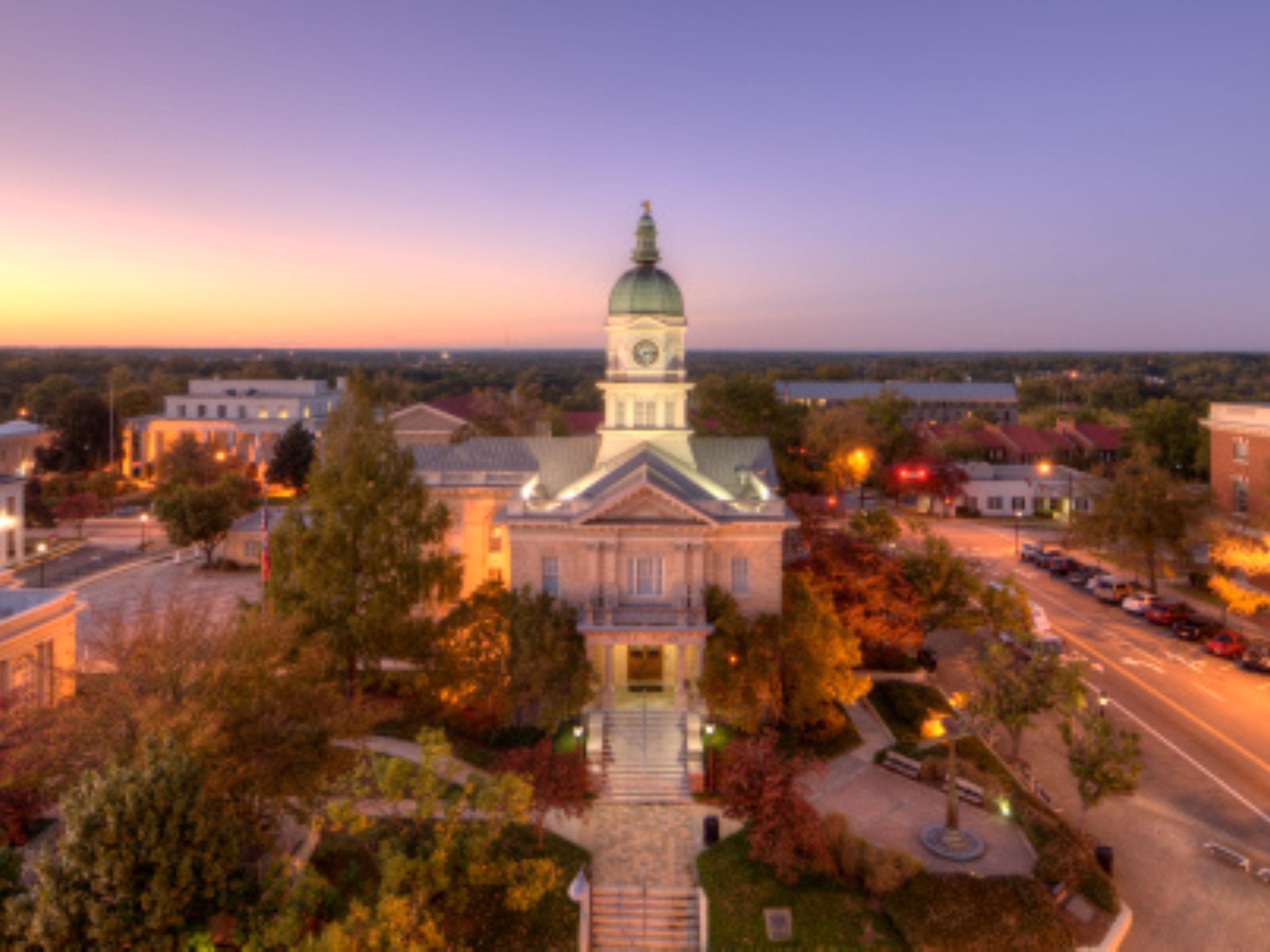 An aerial view capturing an illuminated historic civic building.