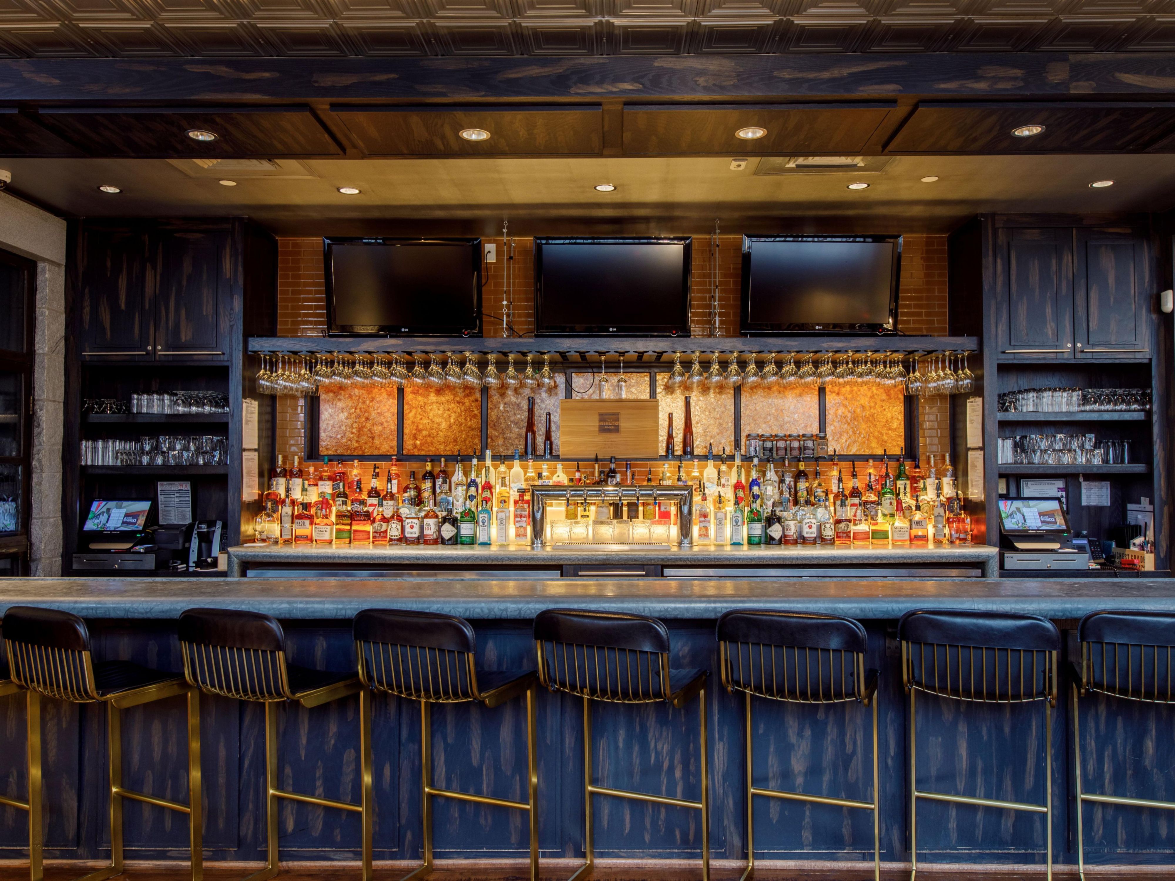 Bartender serves guests at a stylish bar during an event.