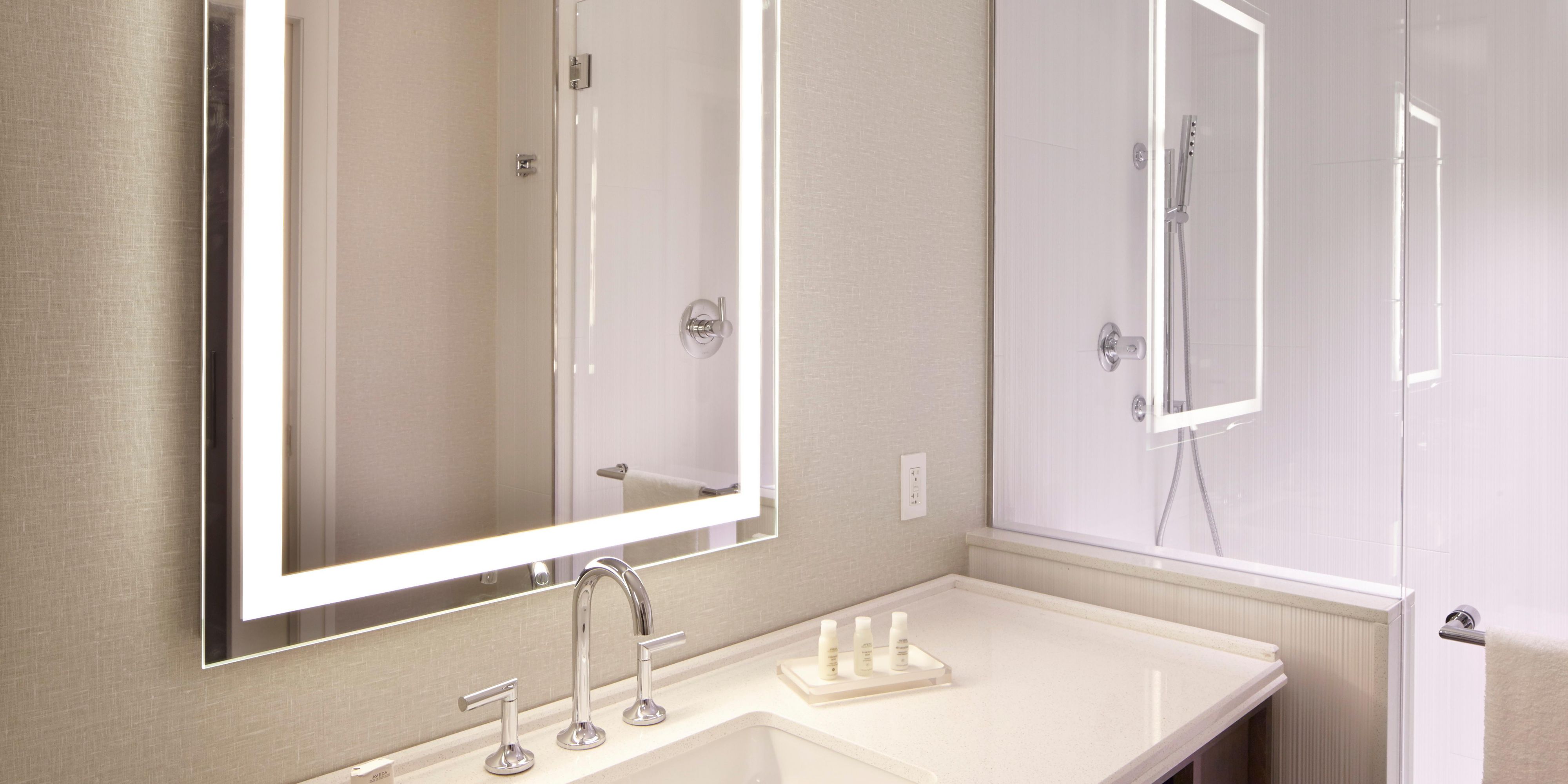 Elegant touch with marble surround and LED vanity mirror.